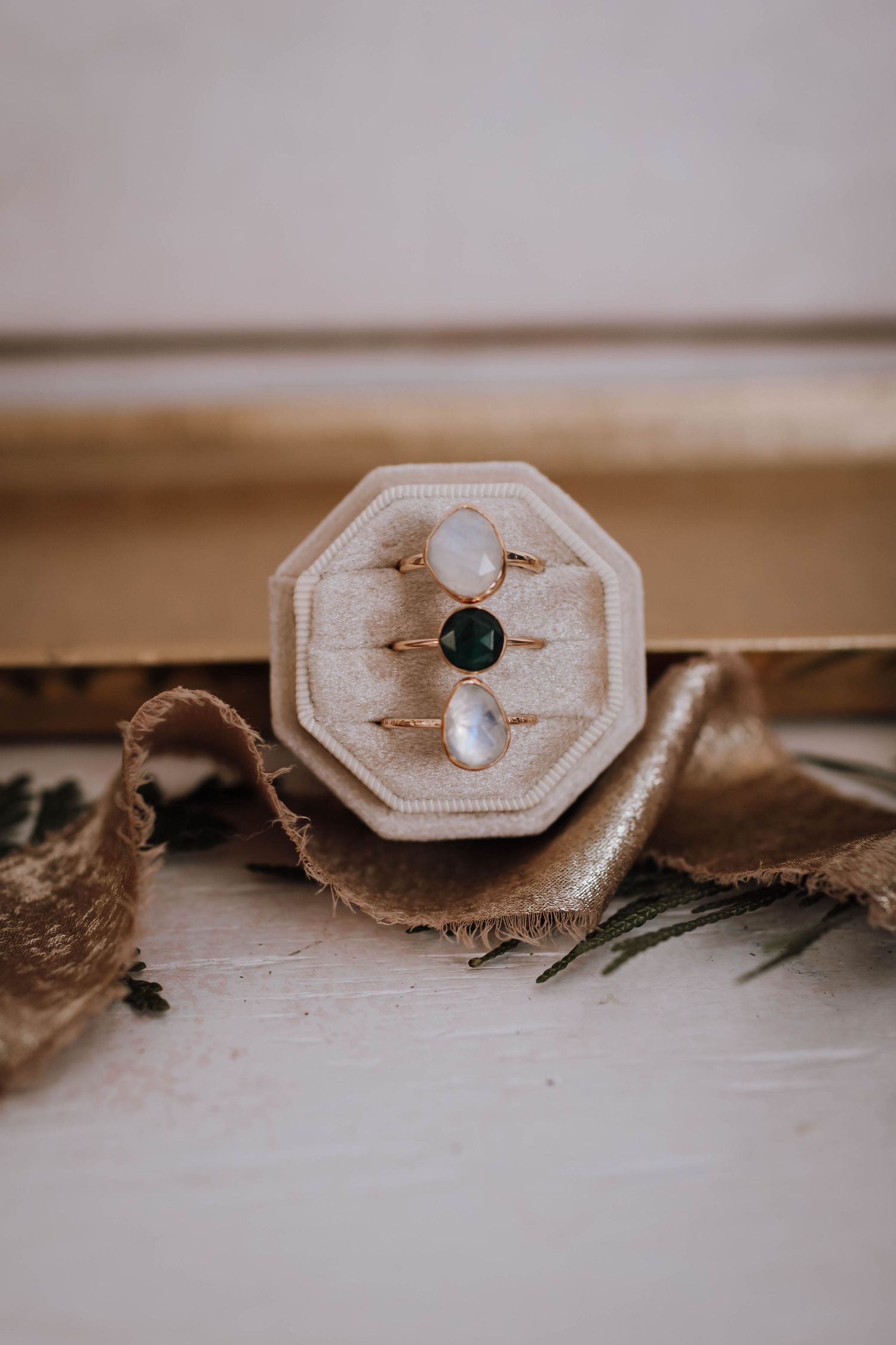 Close-up of engagement rings in an octagonal wooden box with rustic details.