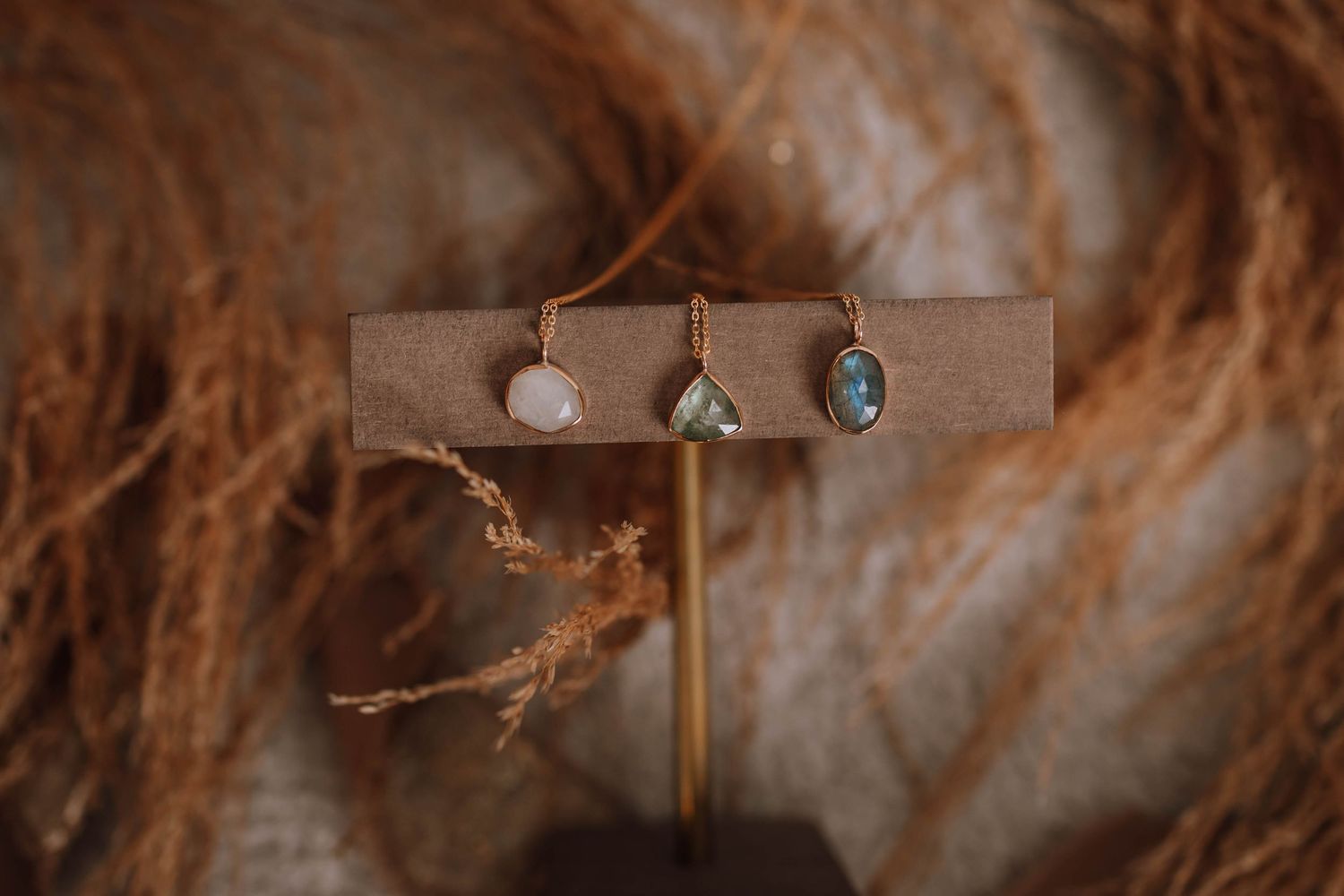 Three vintage-style rings displayed on brown leather holder with textured background.
