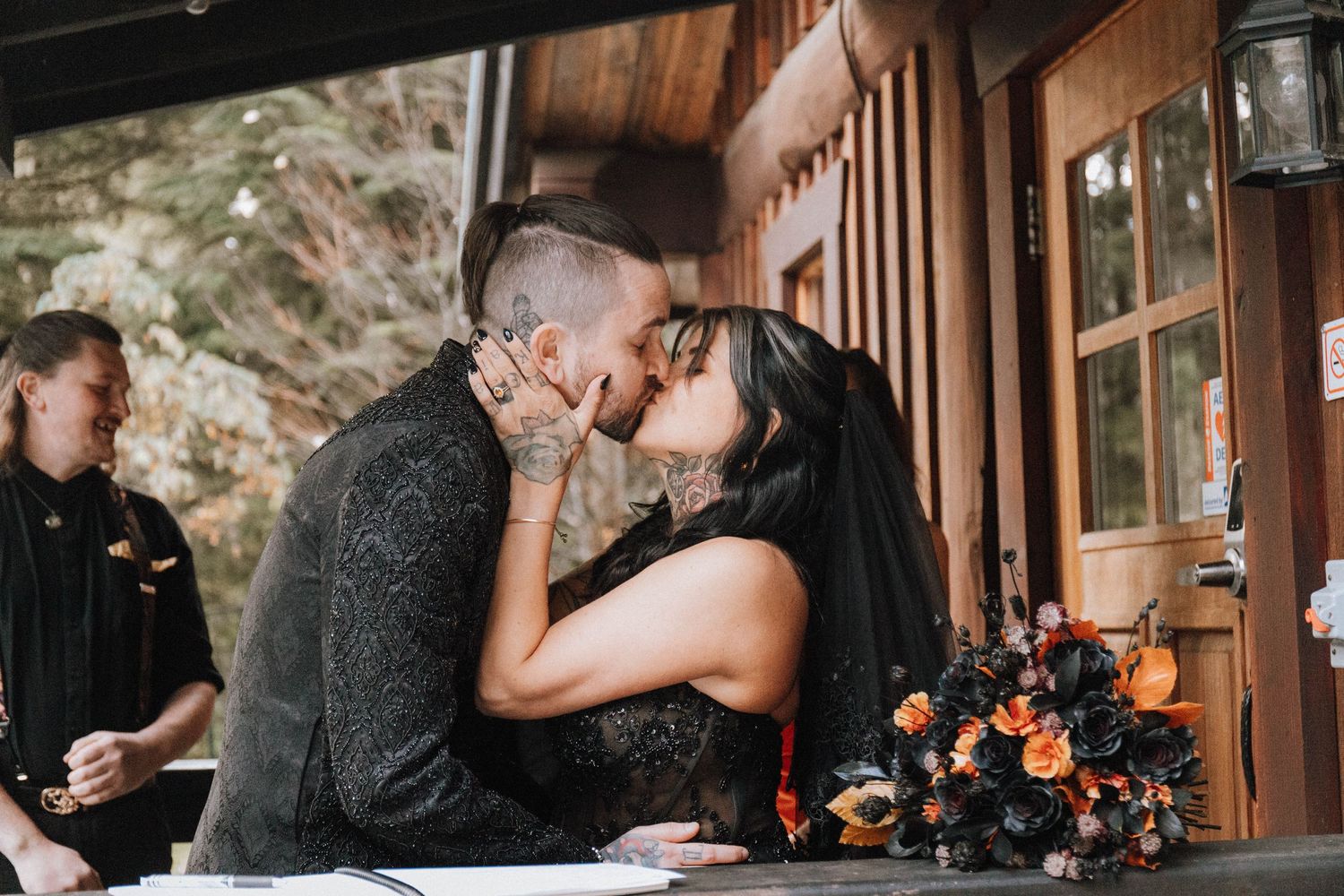 A romantic moment captured during a wedding ceremony at a rustic wooden lodge.