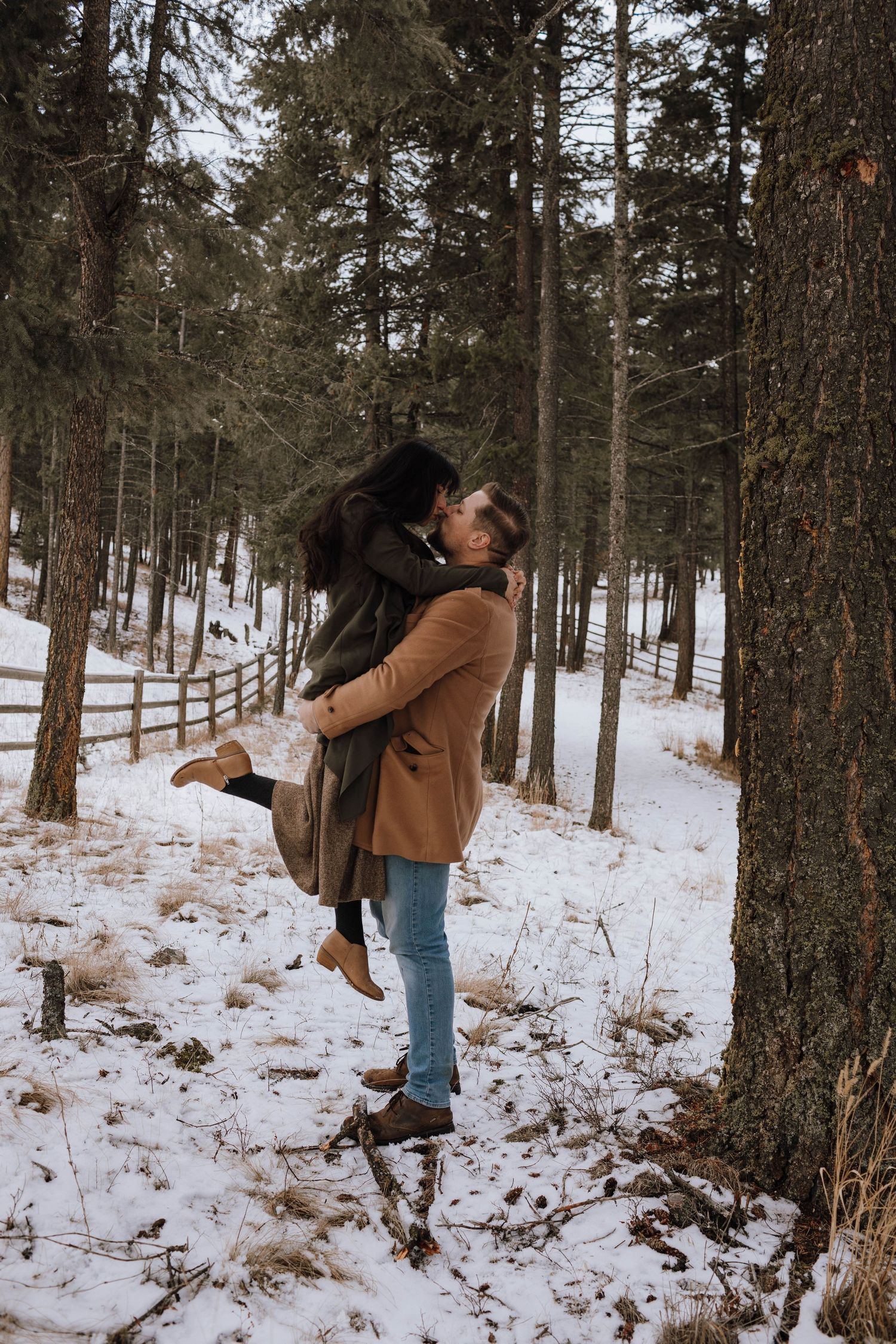 Romantic winter moment between couple in snowy forest setting.