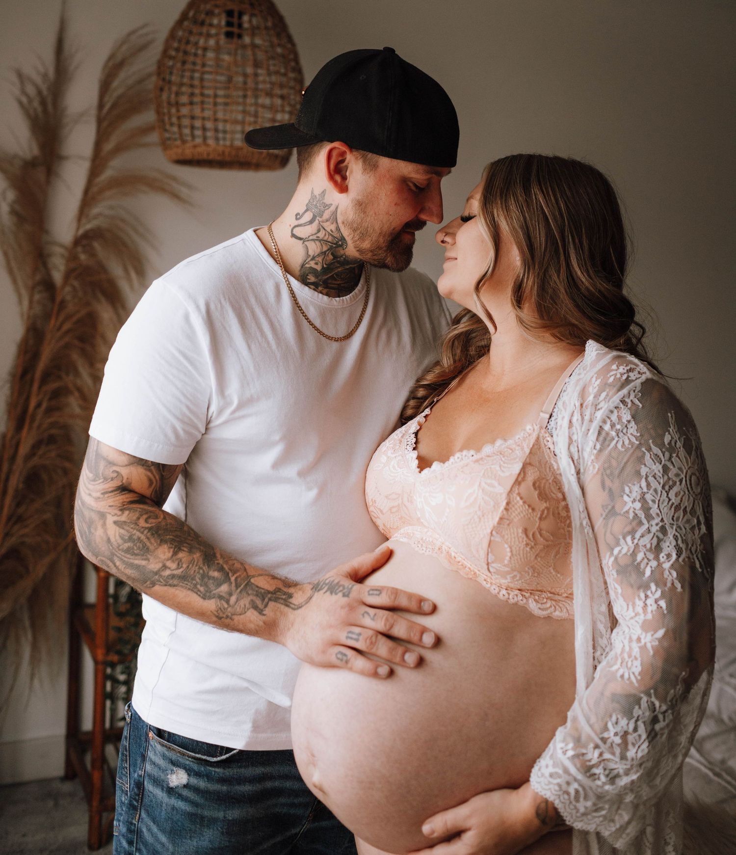An intimate maternity photo with boho decor and natural lighting.