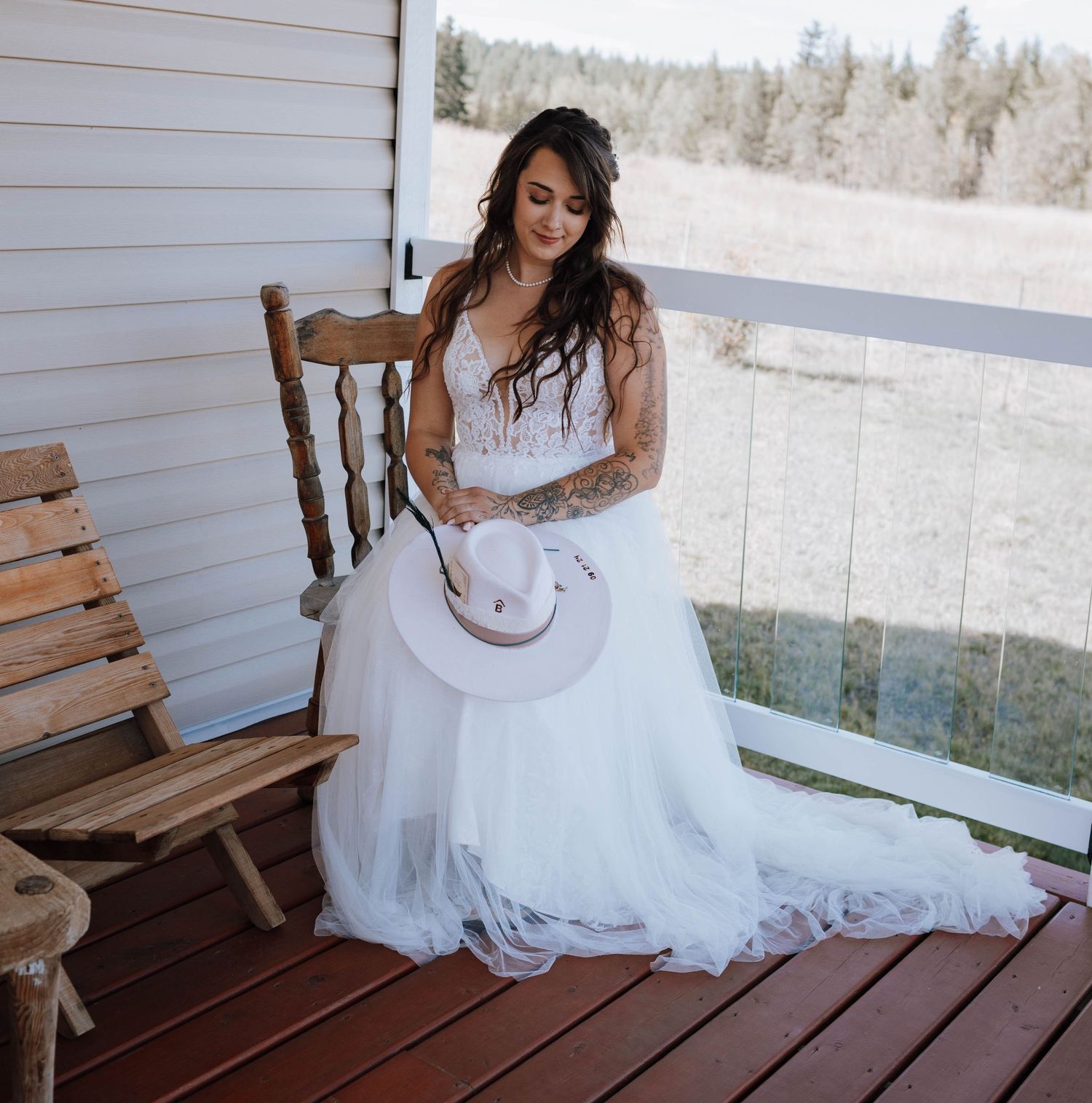 Rustic porch portrait with white wedding dress and cowboy hat.