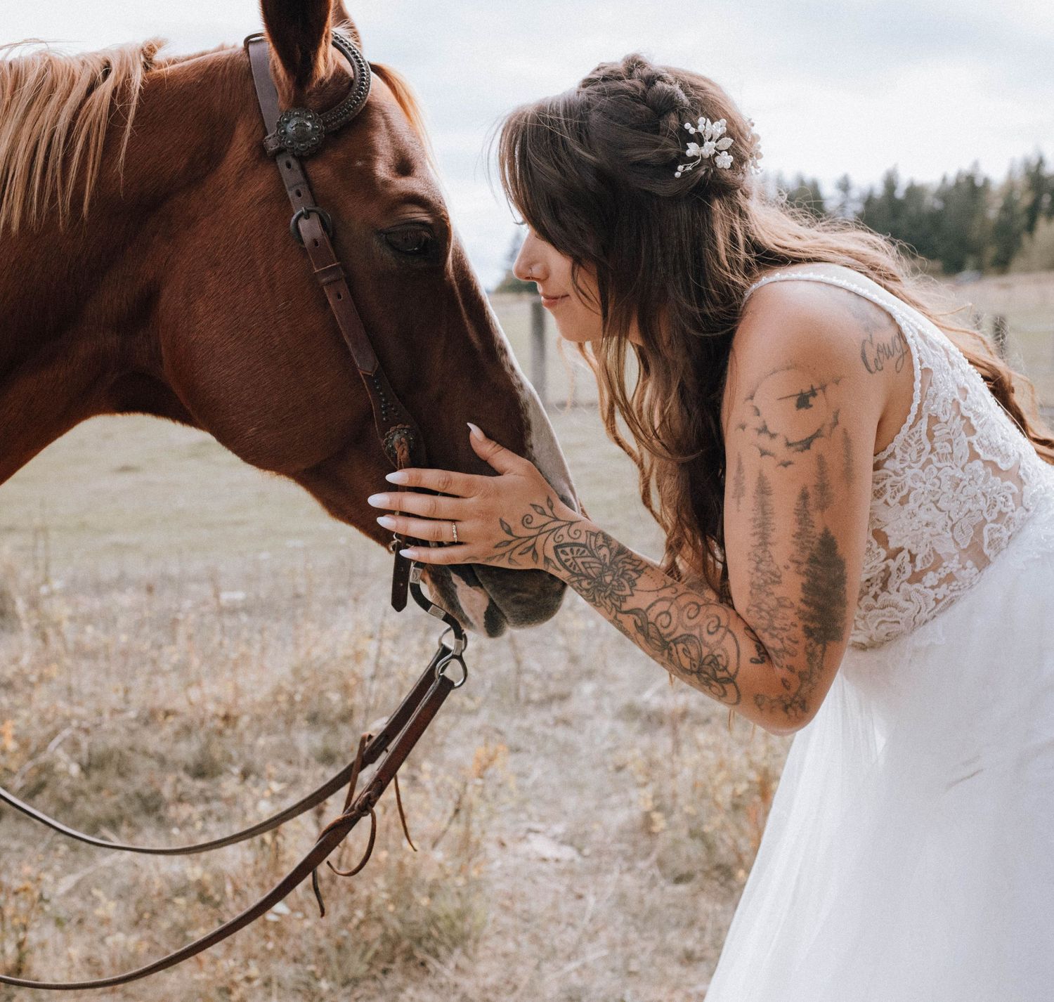 Intimate moment between bride and brown horse showing wedding dress details.