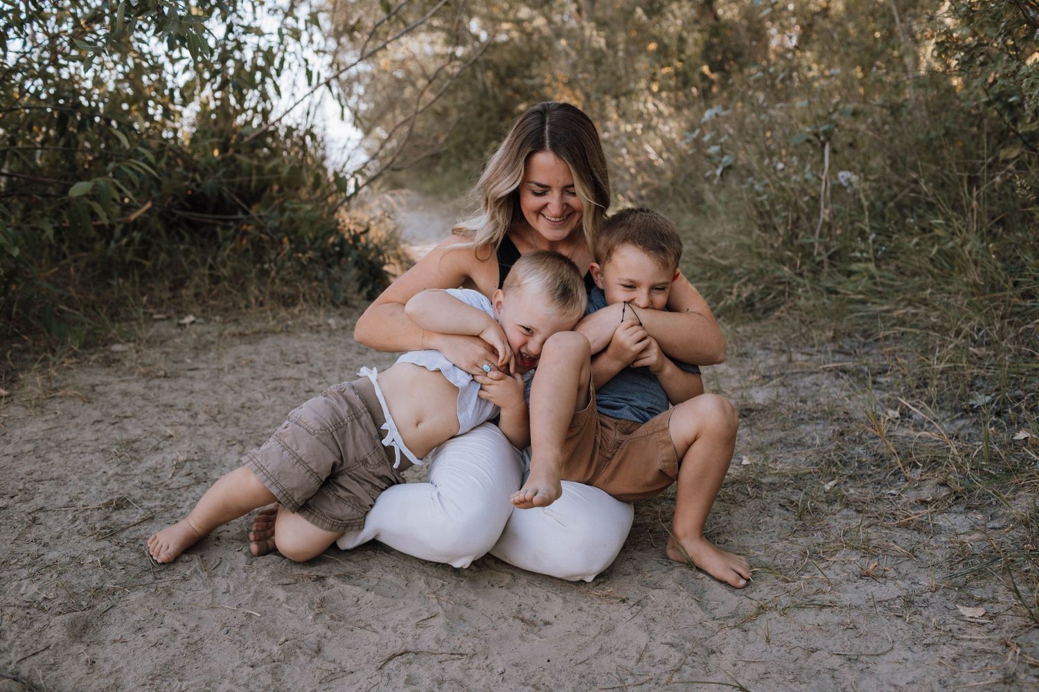A relaxed family moment captured on a dirt path surrounded by greenery.