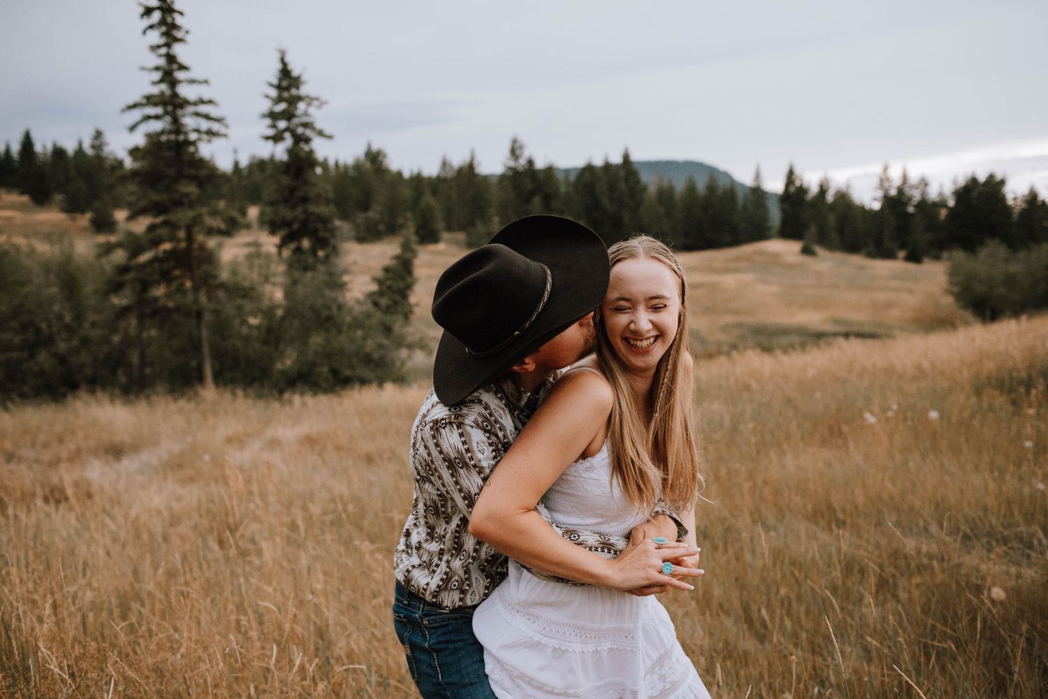 A sweet embrace in a golden mountain meadow during an autumn photoshoot.