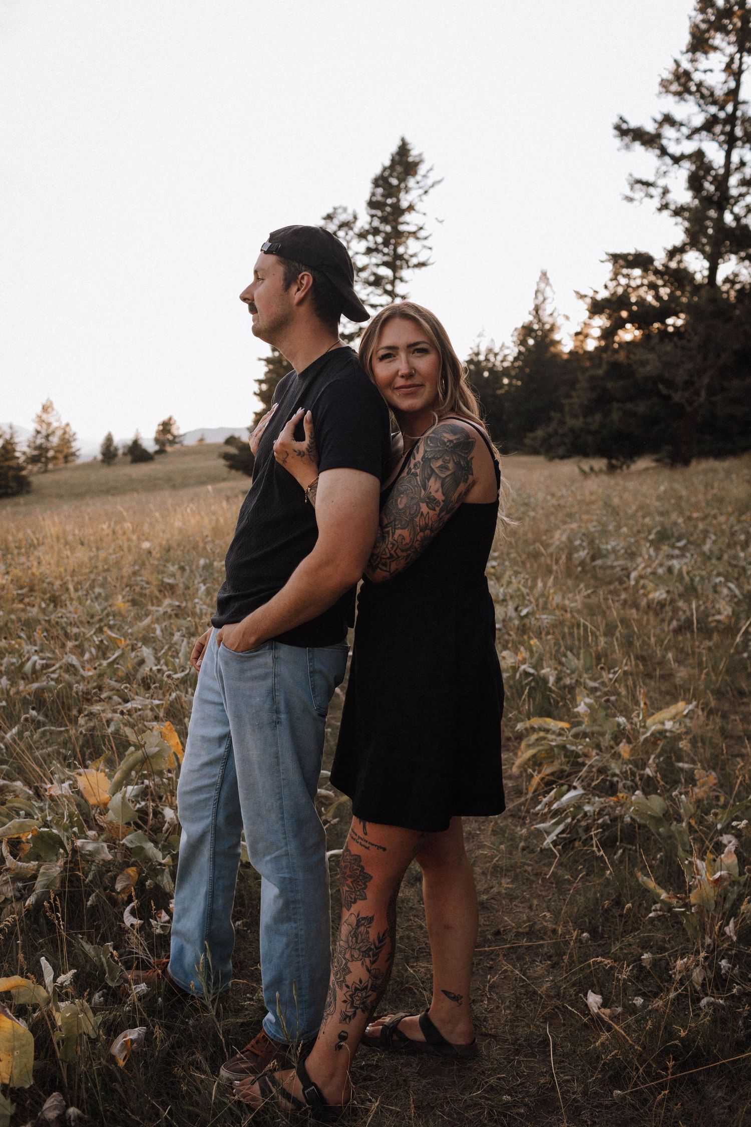 A couple shares an intimate moment together in a golden field at sunset.