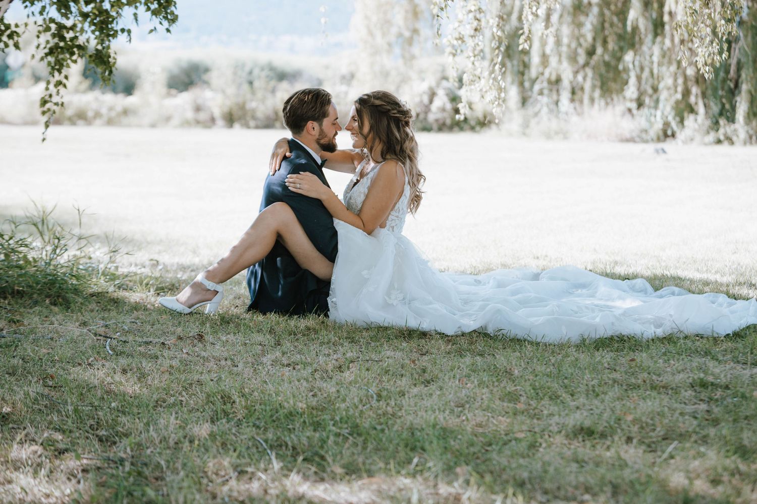 Intimate wedding portrait taken beneath a willow tree on a sunny day.