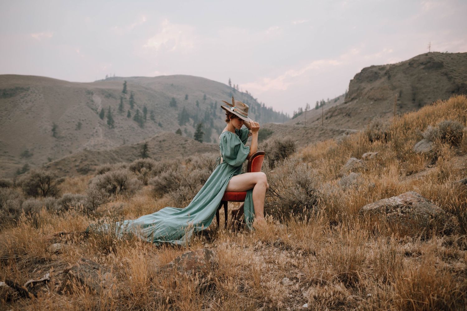 Dramatic mountain landscape photo featuring flowing teal dress against rugged terrain.