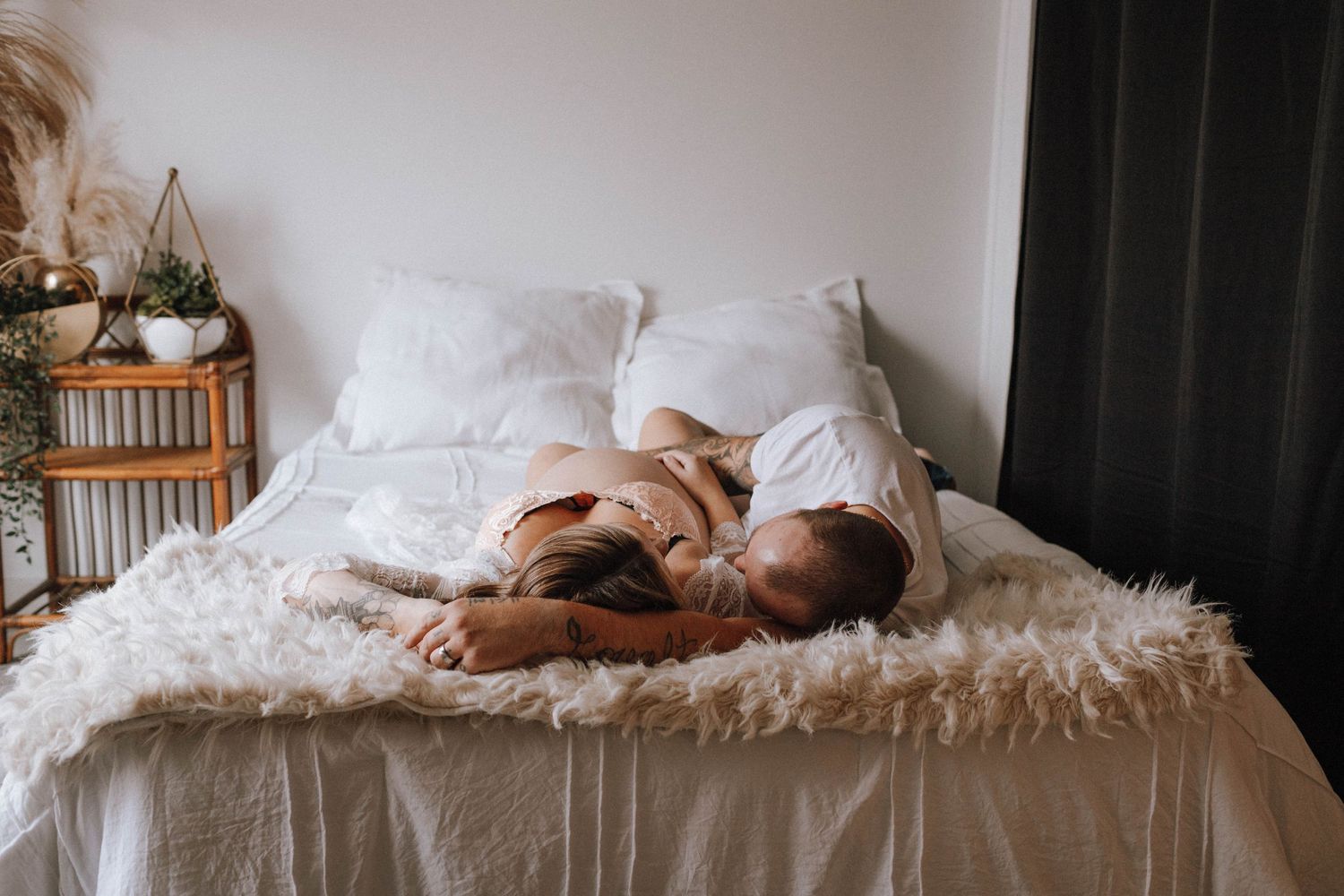 Intimate lifestyle photo on a white fluffy bed with neutral tones.