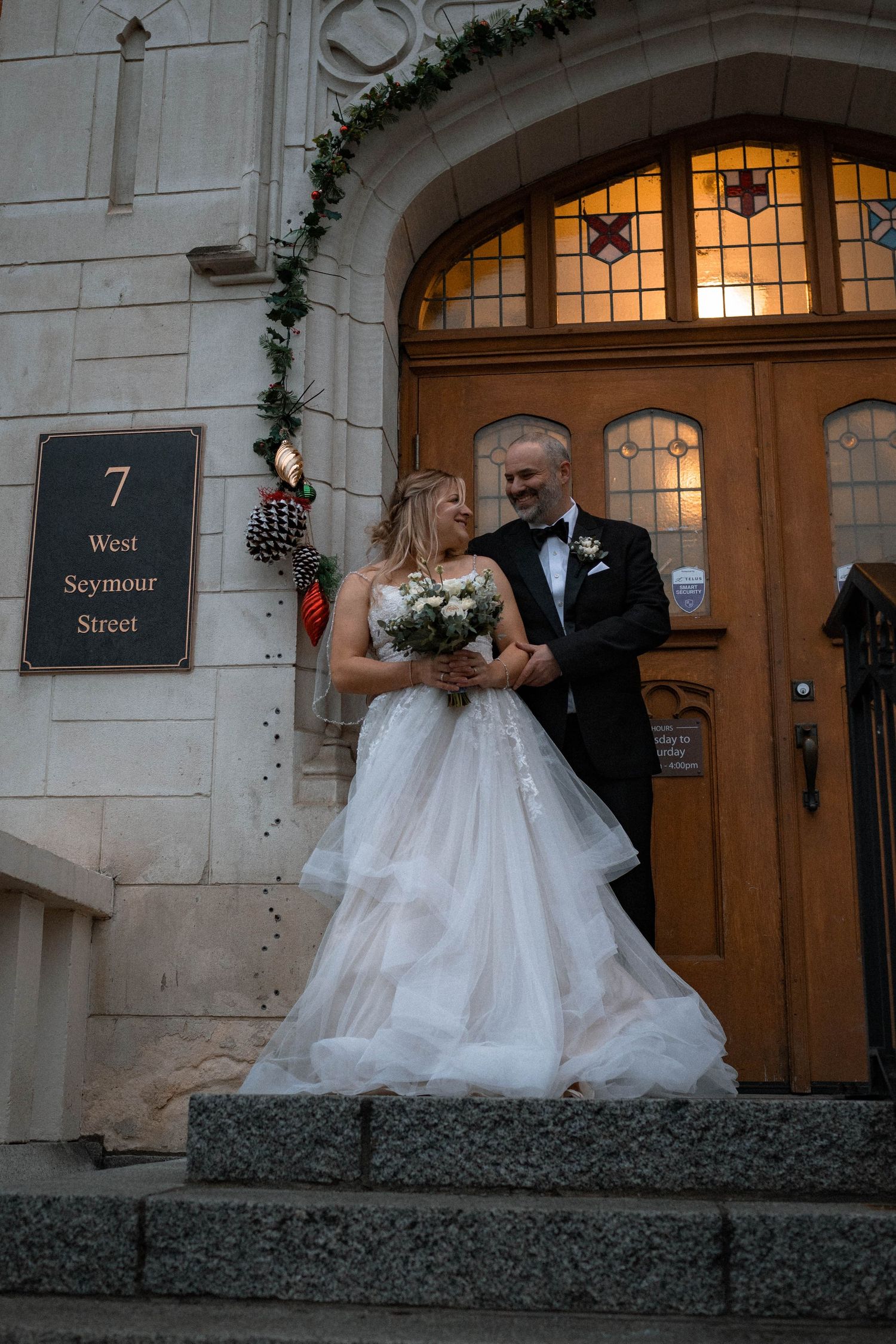 Wedding couple posing at 7 West Seymour Street entrance with illuminated archway.