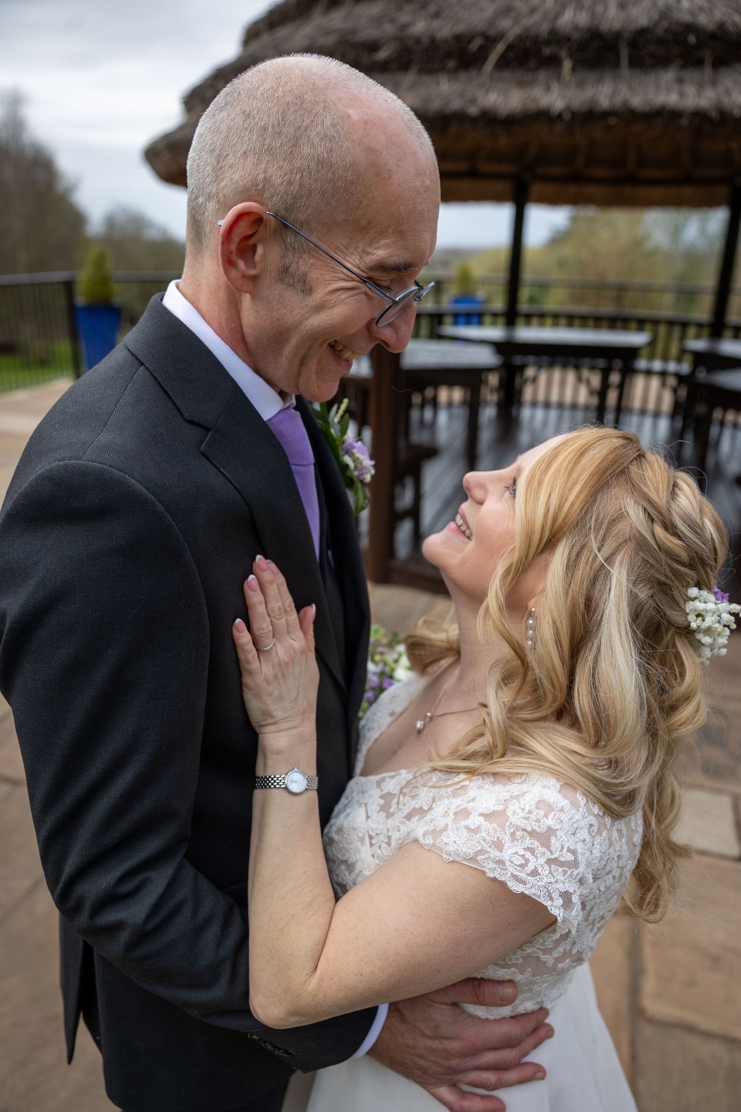 An intimate moment shared between a couple on their wedding day under a gazebo.