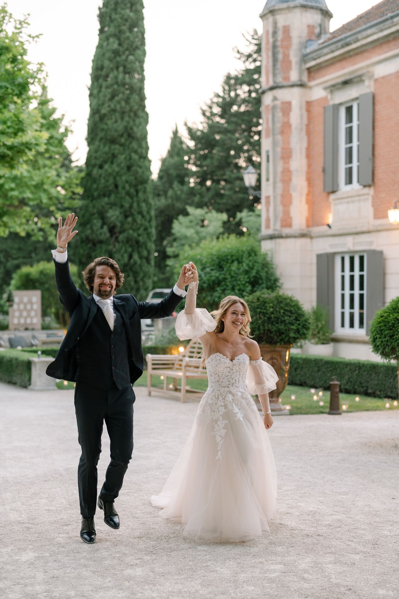 Joyful couple celebrates while walking outside a historic European building.