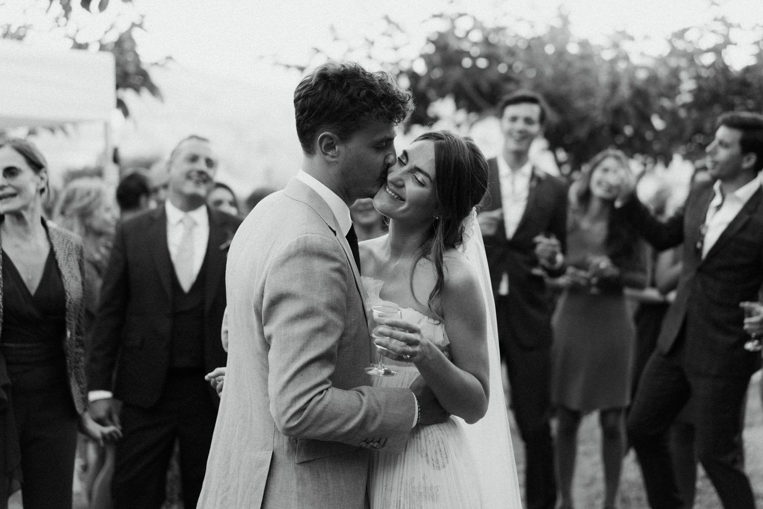 Black and white photo of wedding guests dancing and celebrating.