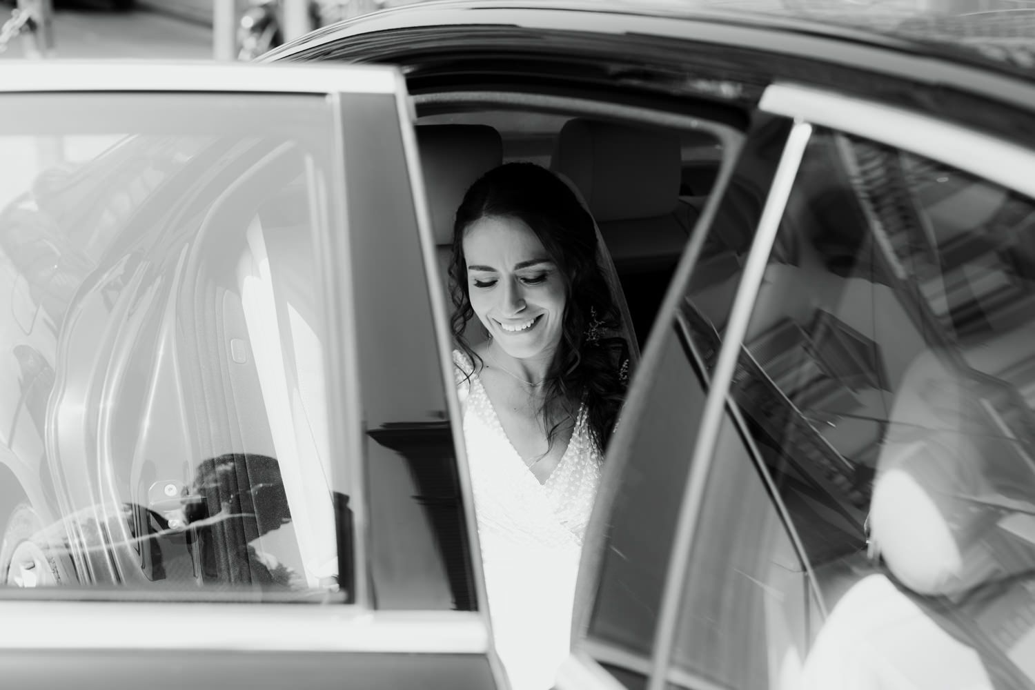 Black and white candid moment of joy captured through a car window.