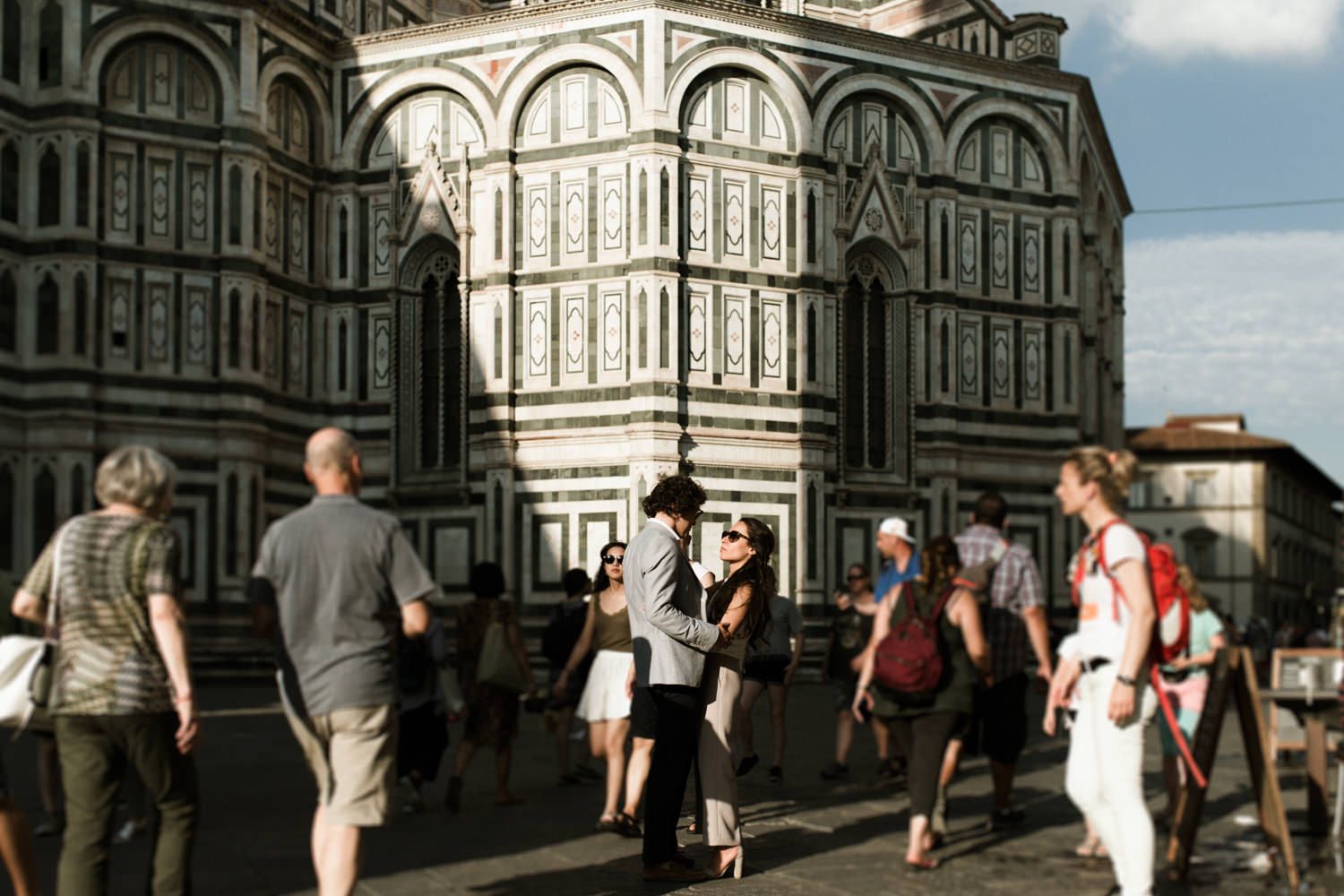 Tourists gathering outside the Florence Duomo's ornate marble facade.
