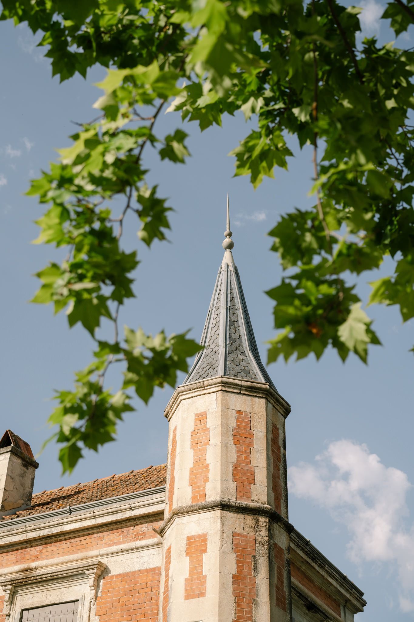 Historic building exterior featuring ornate terracotta turrets and architectural details against blue sky.