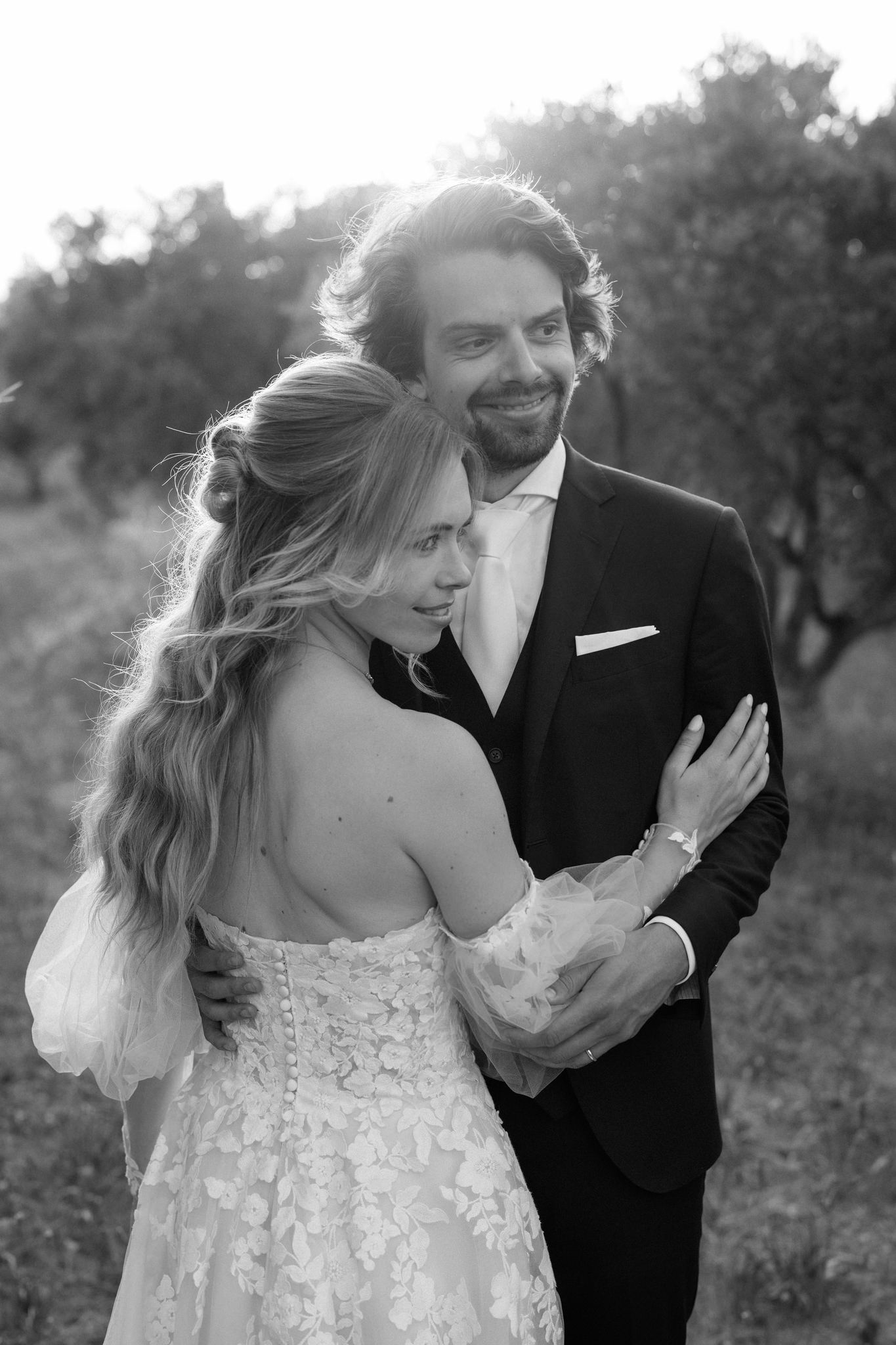 Black and white portrait of a couple sharing an intimate moment outdoors.