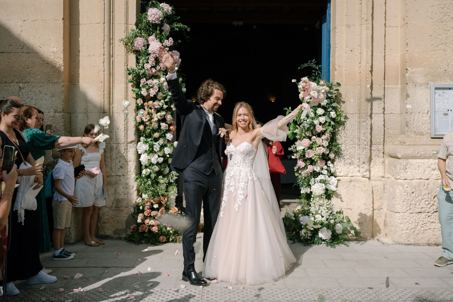 Floral-adorned church entrance with pink and white roses creating an elegant wedding archway.
