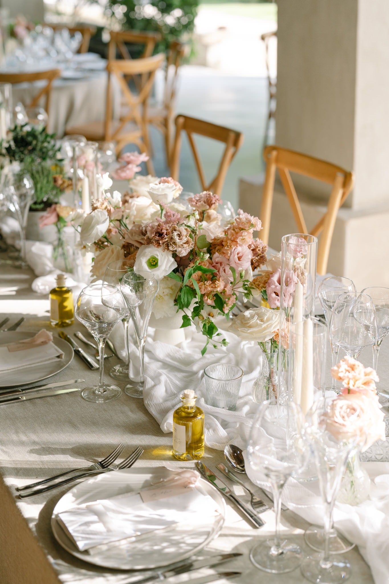 Wedding table settings with crystal glassware, white plates, and delicate floral accents.