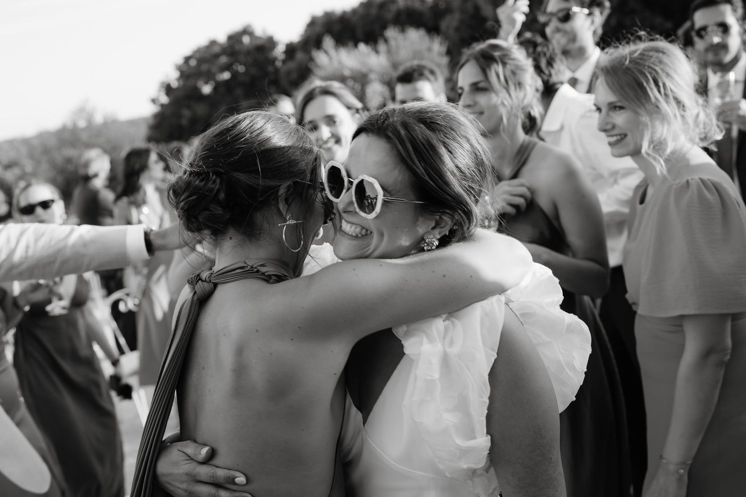 Wedding guests dance and celebrate together during an outdoor reception.