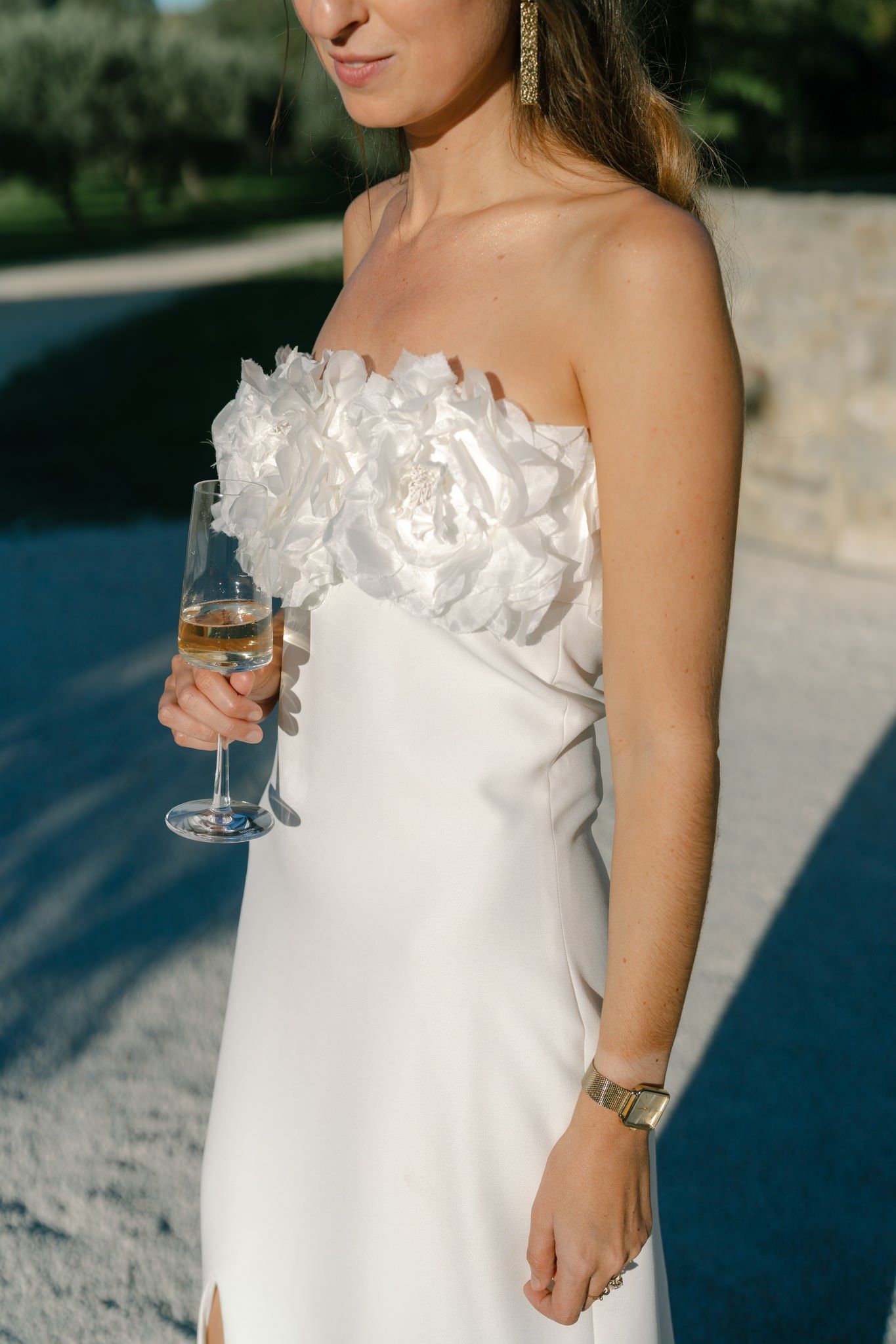 Close up details of a white strapless wedding dress with ruffled neckline.