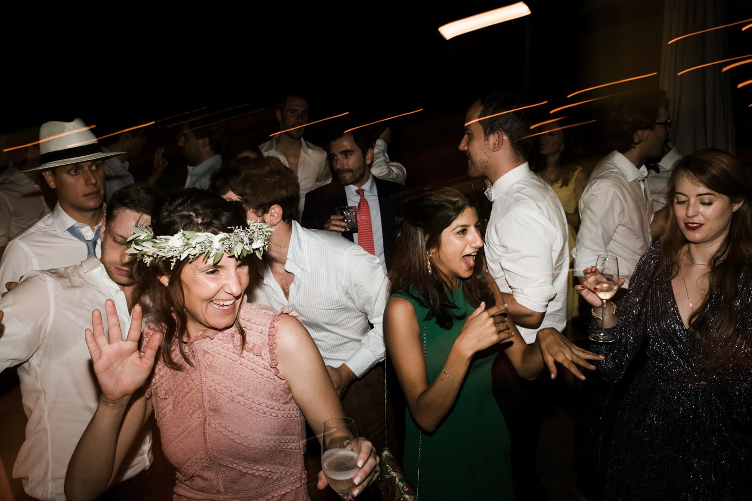 Lively dance floor scene with wedding guests celebrating at an evening reception.