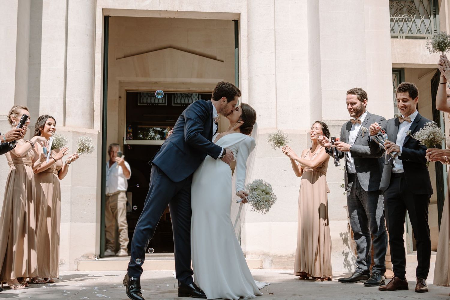 Wedding guests gather outside a church entrance for a celebratory moment.
