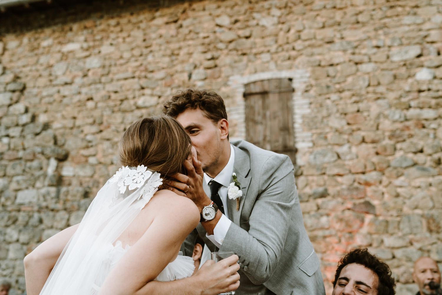 Wedding celebration moments captured against rustic stone wall backdrop.