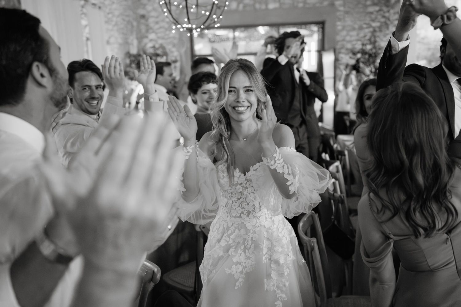 Black and white photo of wedding guests celebrating on the dance floor.