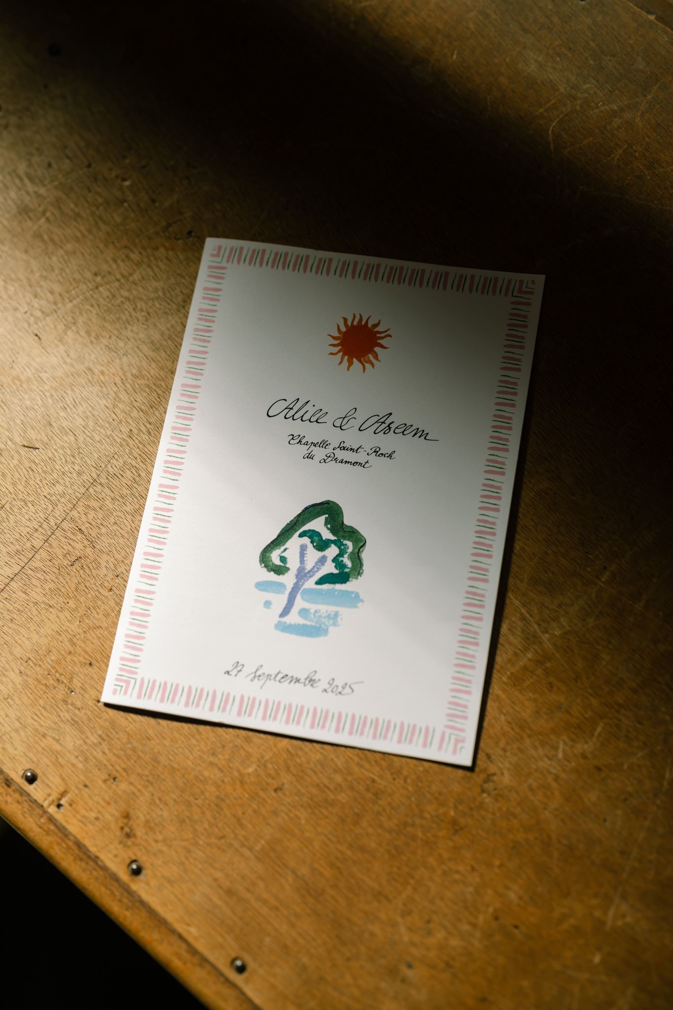 Wedding invitation cards displayed in sequence on a wooden surface with decorative designs.