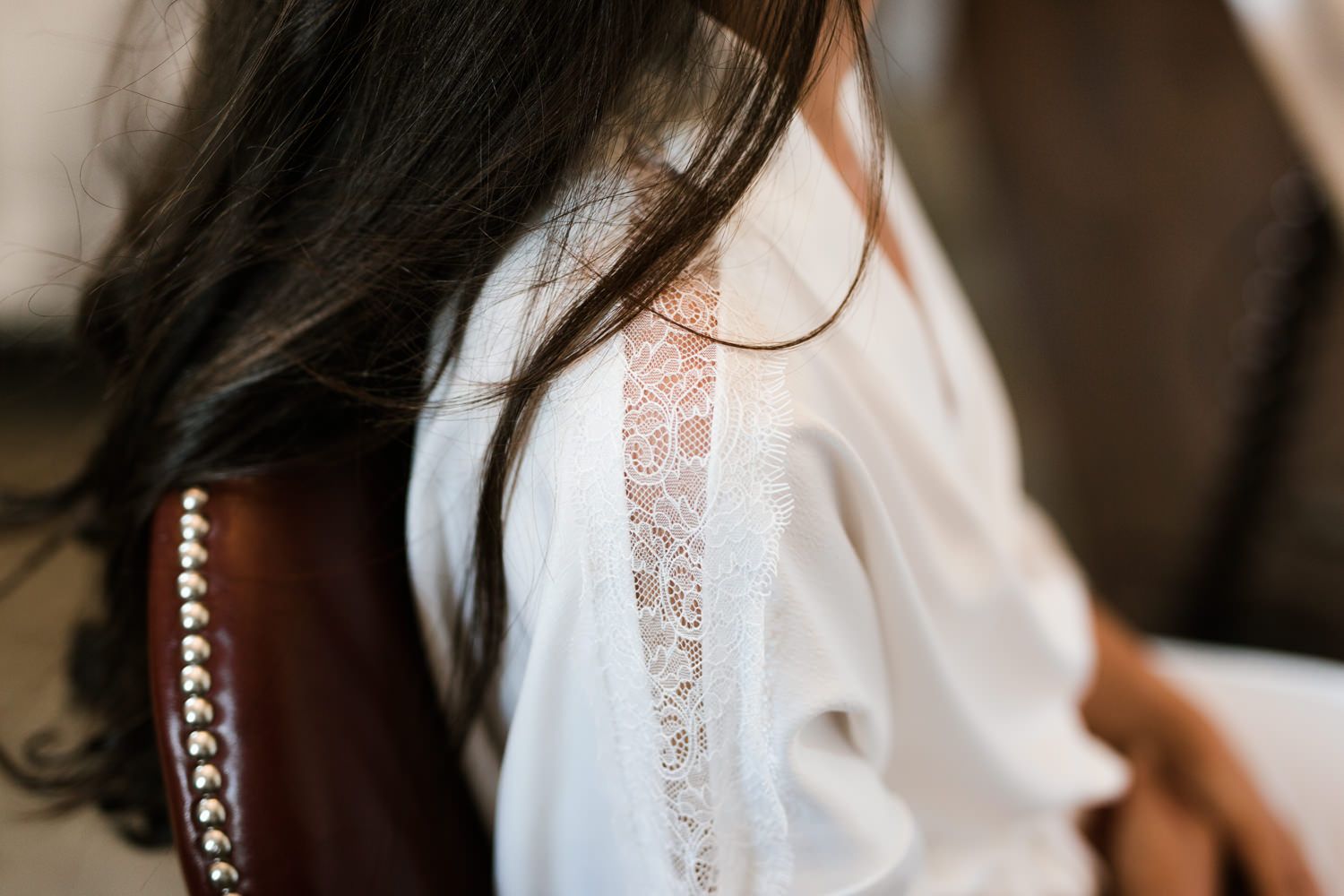 Delicate lace details on white fabric in soft natural lighting.
