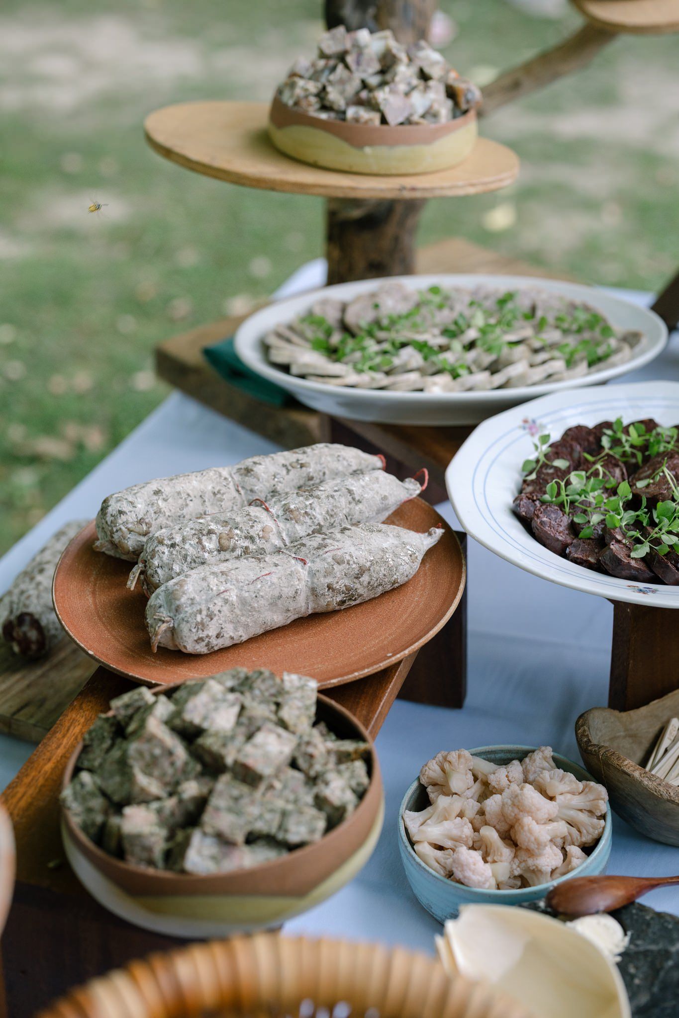 Various appetizers and dishes displayed on rustic platters at a buffet setting.
