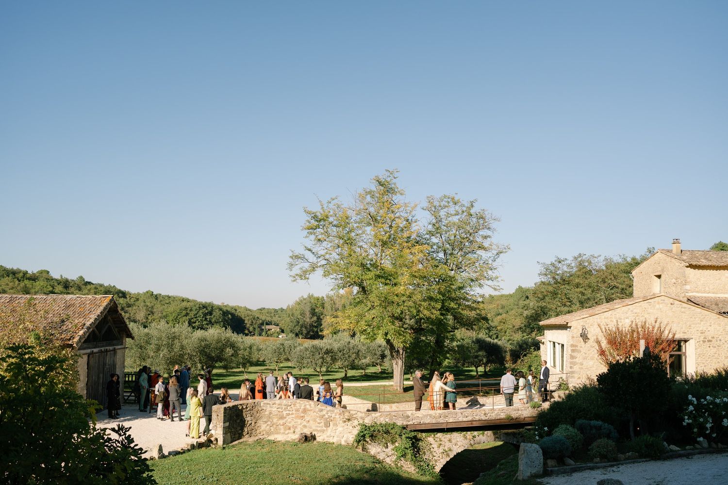 Stone buildings and courtyard of a rustic Mediterranean villa under blue sky.