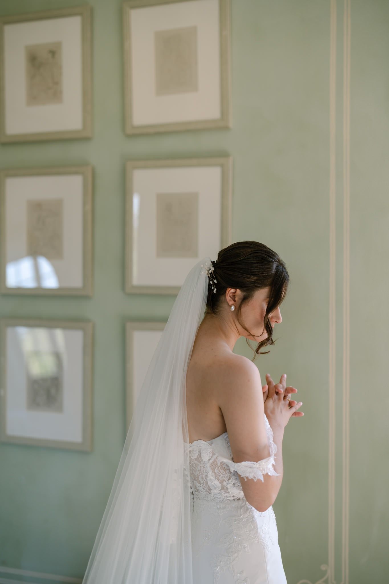 Elegant bridal portrait in a mint green room with framed artwork.