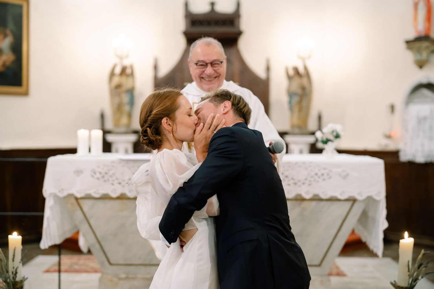 Intimate moment during church wedding ceremony with guests looking on.