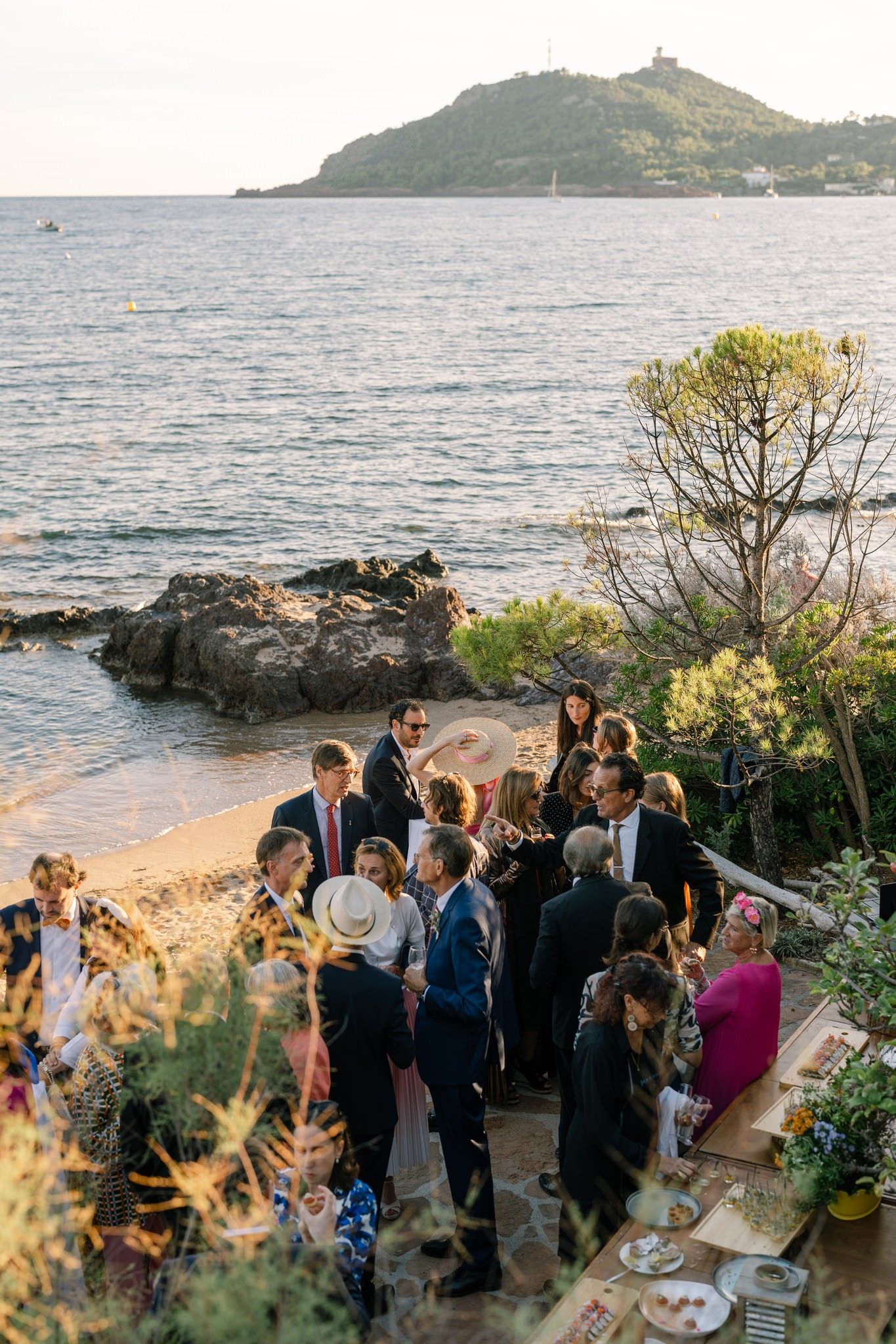 Wedding reception gathering on a coastal terrace overlooking the Mediterranean Sea.