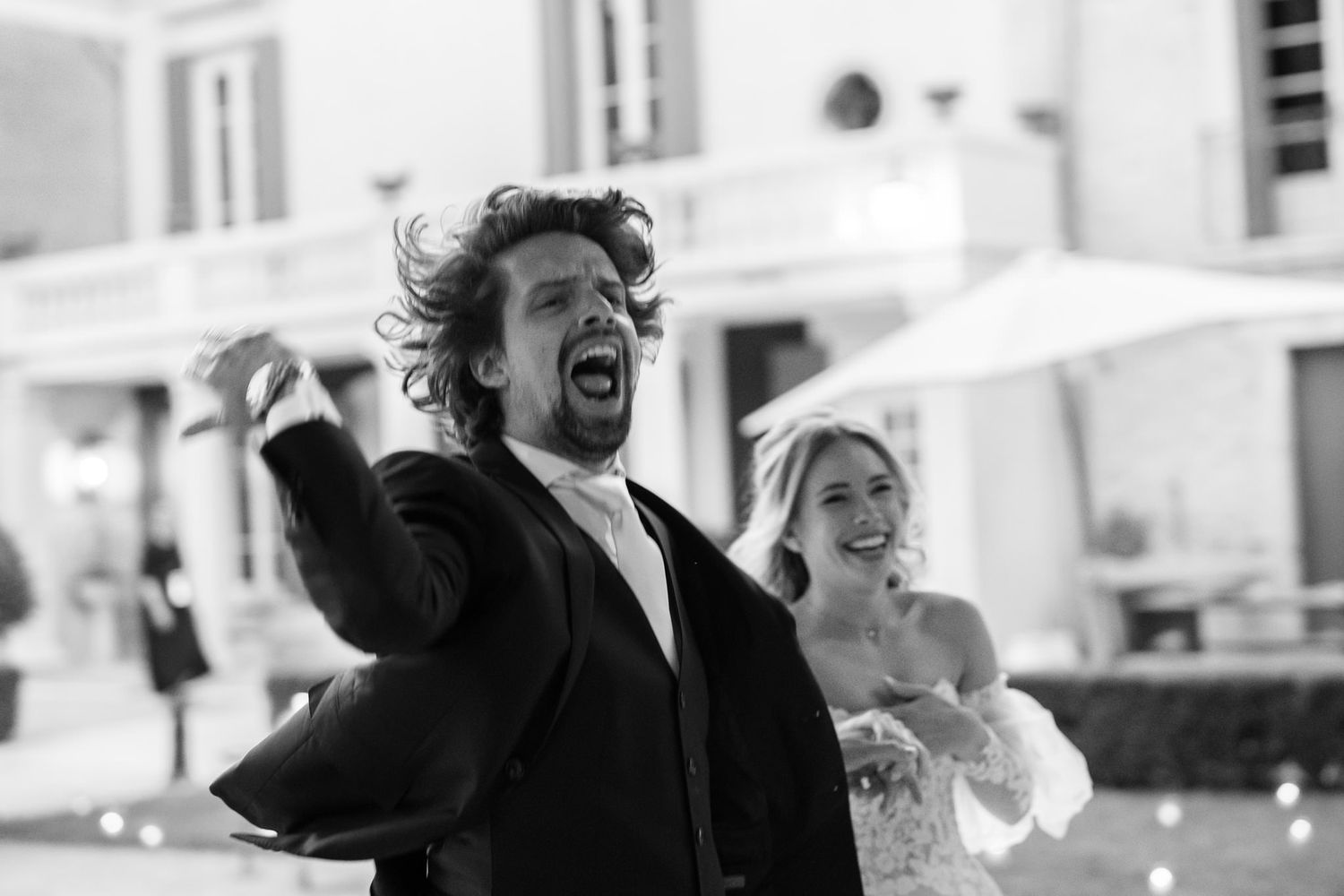 Candid black and white photo of joyful moments at a wedding celebration.