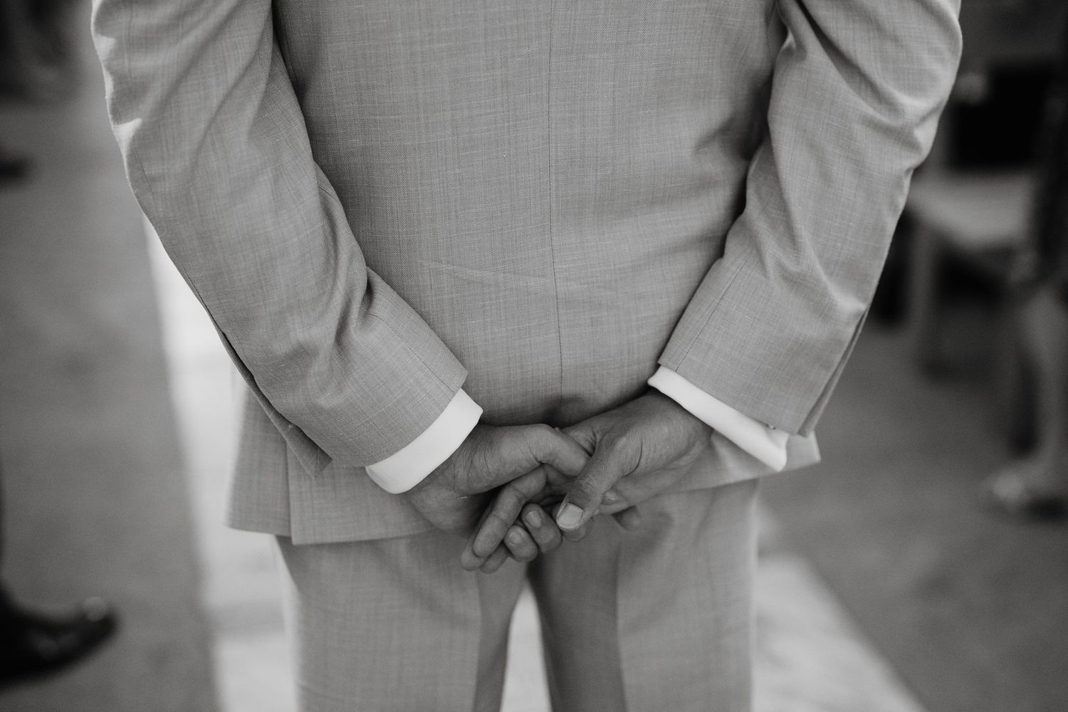 Detail shot of groomsmen in grey suits standing in formal formation.