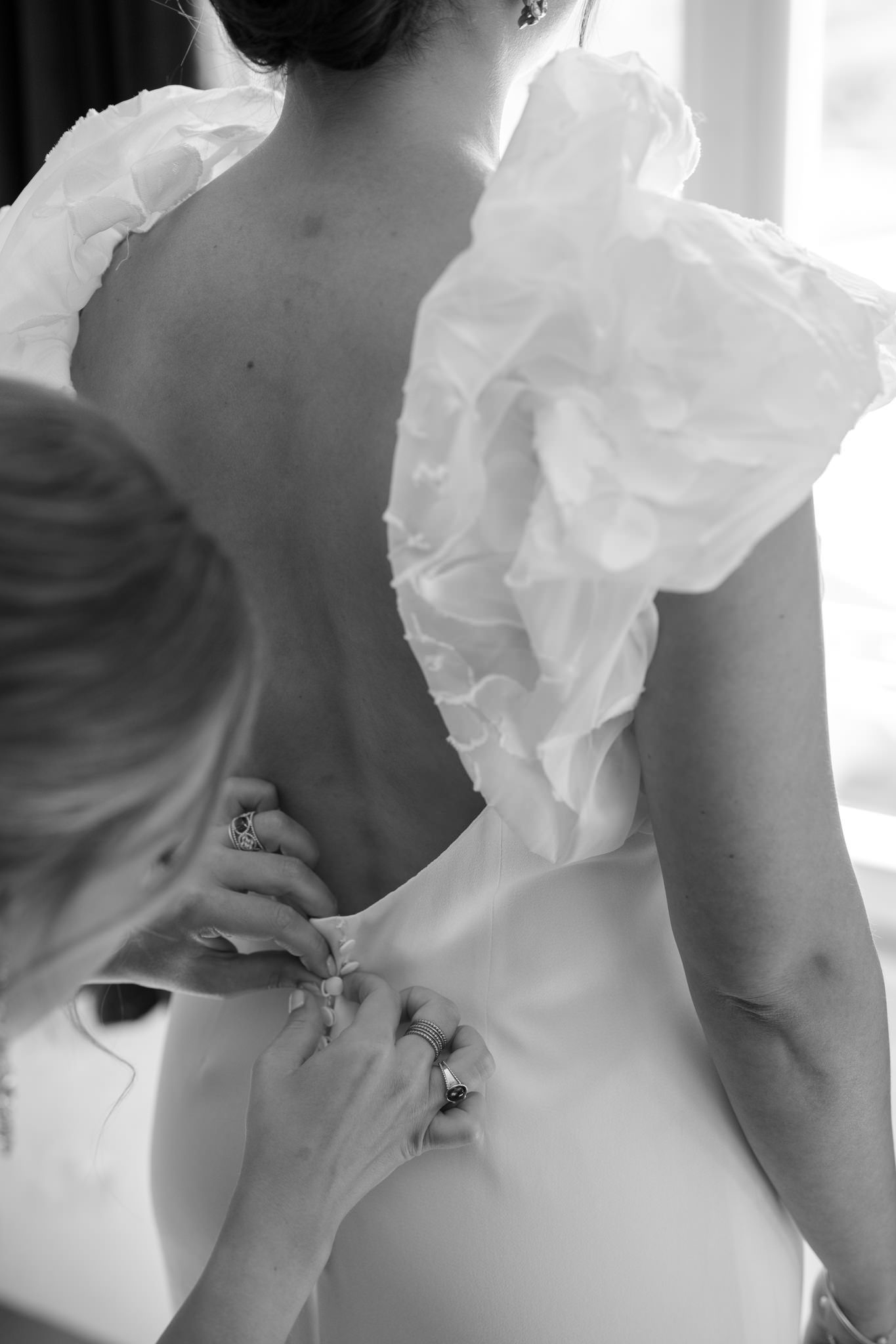 Detail shots of white ruffled wedding dress fabric in natural window light.
