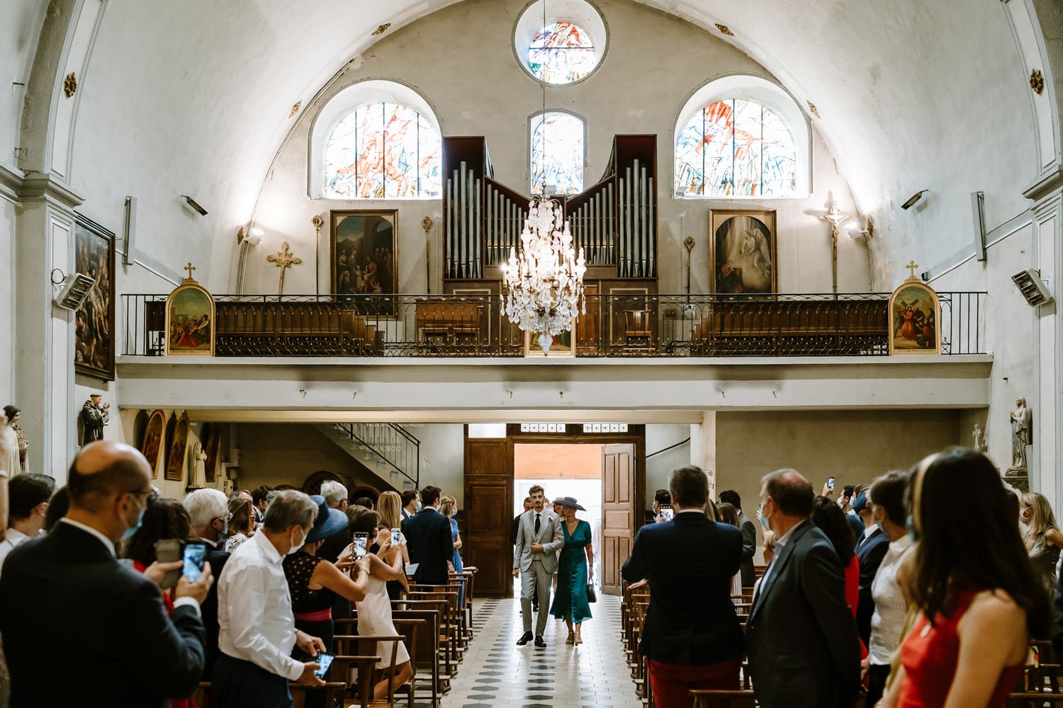 Grand church interior with vaulted ceilings, chandeliers and religious artwork.