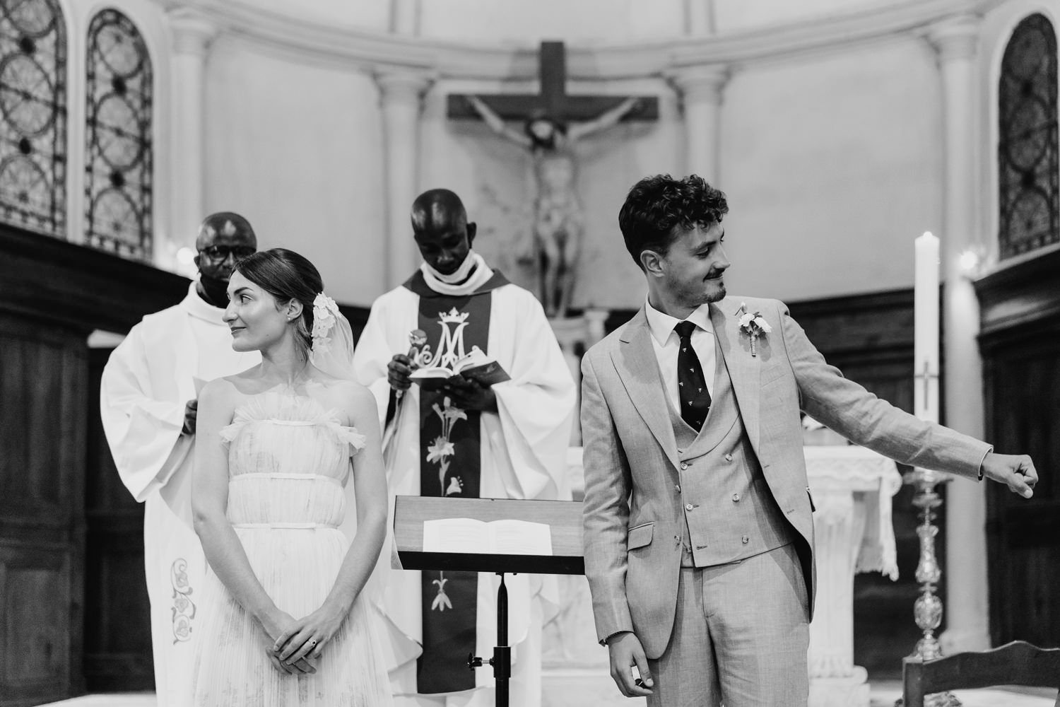 A joyful moment during a church wedding ceremony with the couple and officiant at the altar.