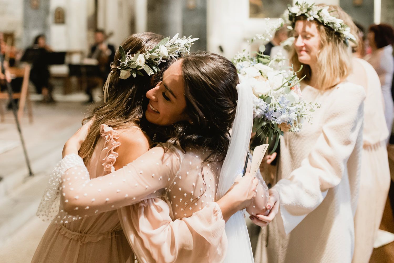 Romantic wedding celebration with bridesmaids in blush pink dresses and floral crowns.