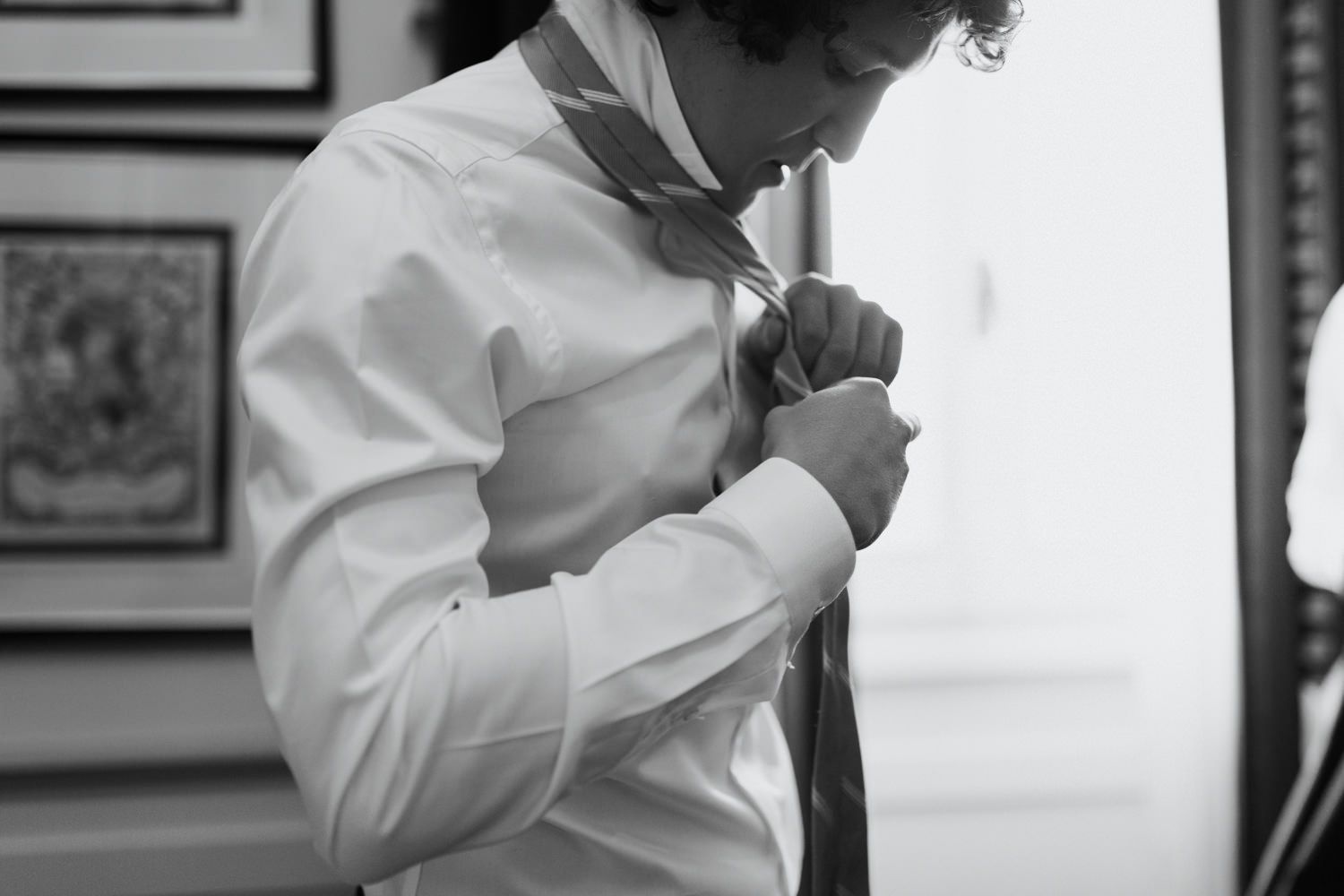 Close-up shot of someone adjusting a tie while getting dressed.