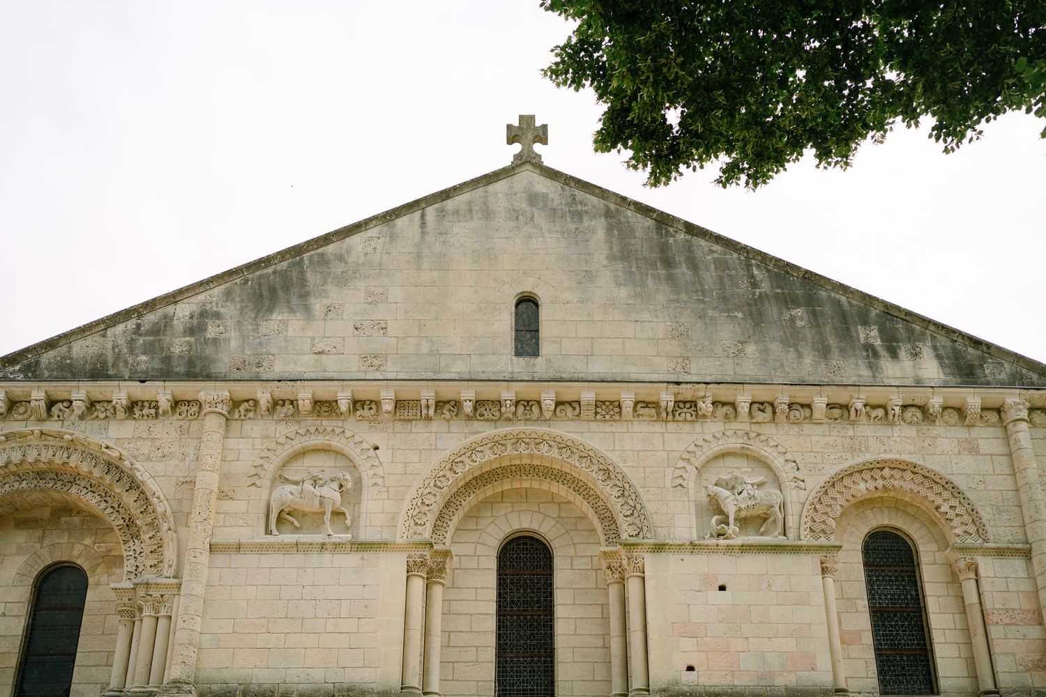 Exterior view of a historic stone church with cross and architectural details.