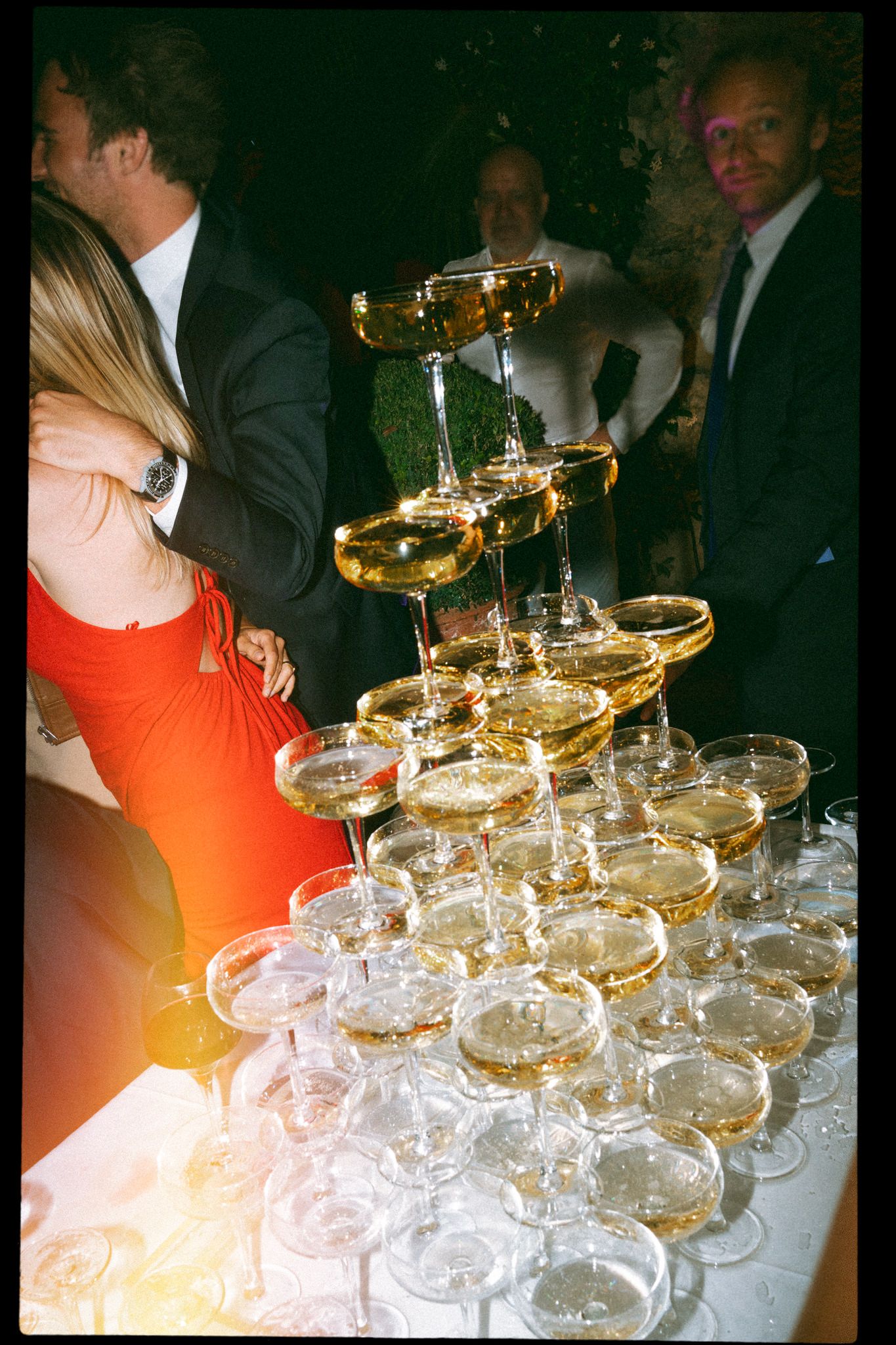 Champagne tower setup with coupe glasses arranged in elegant tiers.