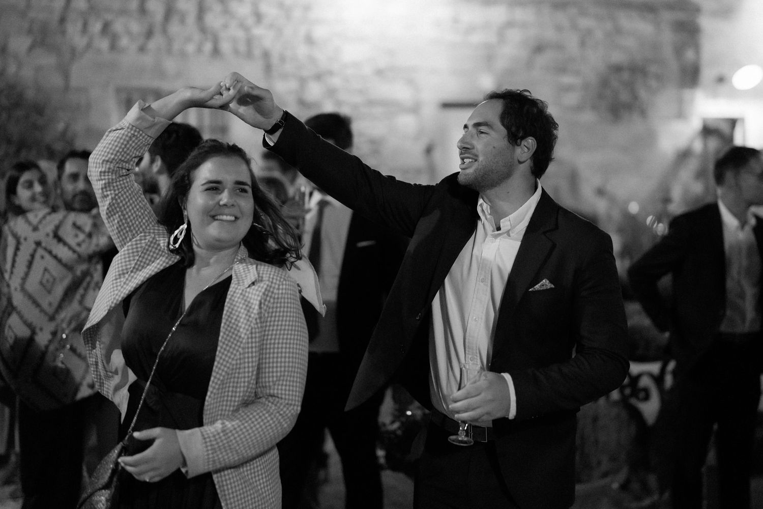 Black and white photos showing lively dancing and celebration at an evening reception.