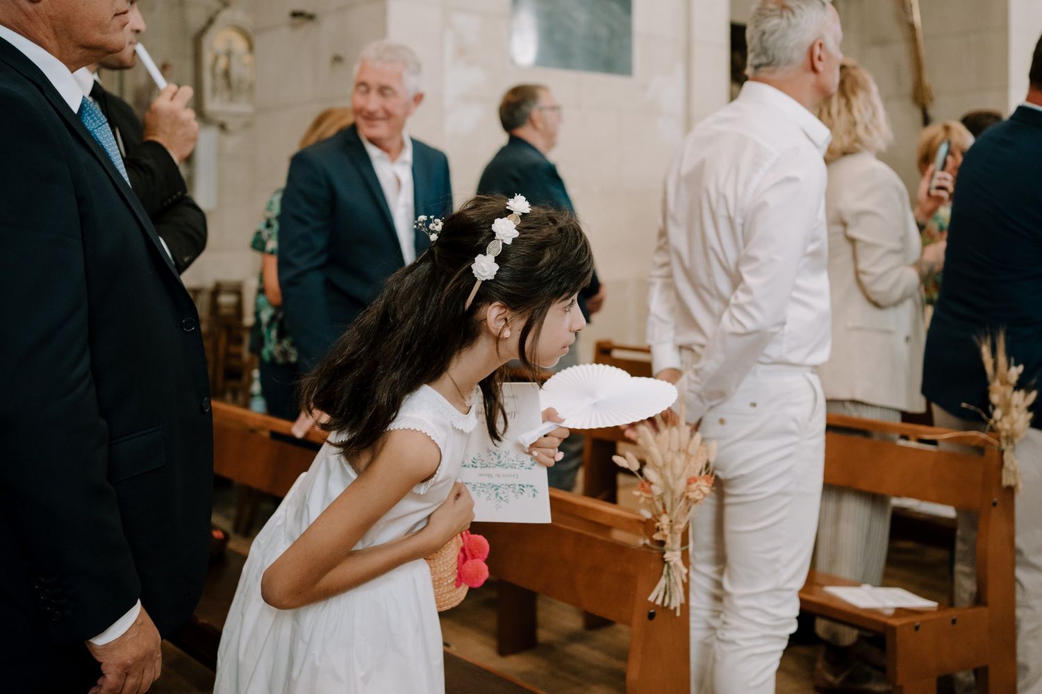 Candid moments of wedding guests and clergy interacting during a traditional church ceremony.