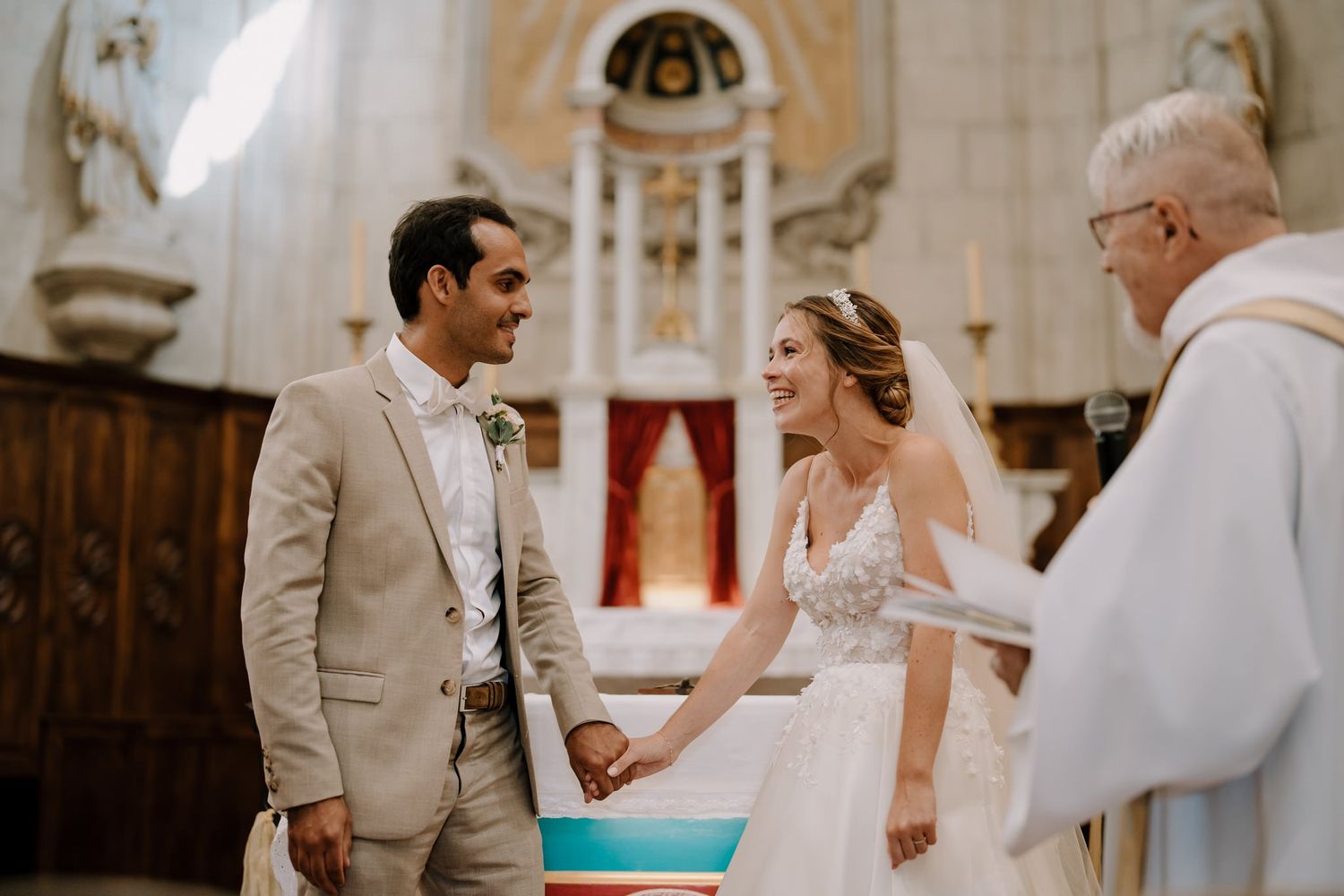 Intimate moment during church wedding ceremony with classic architectural details.