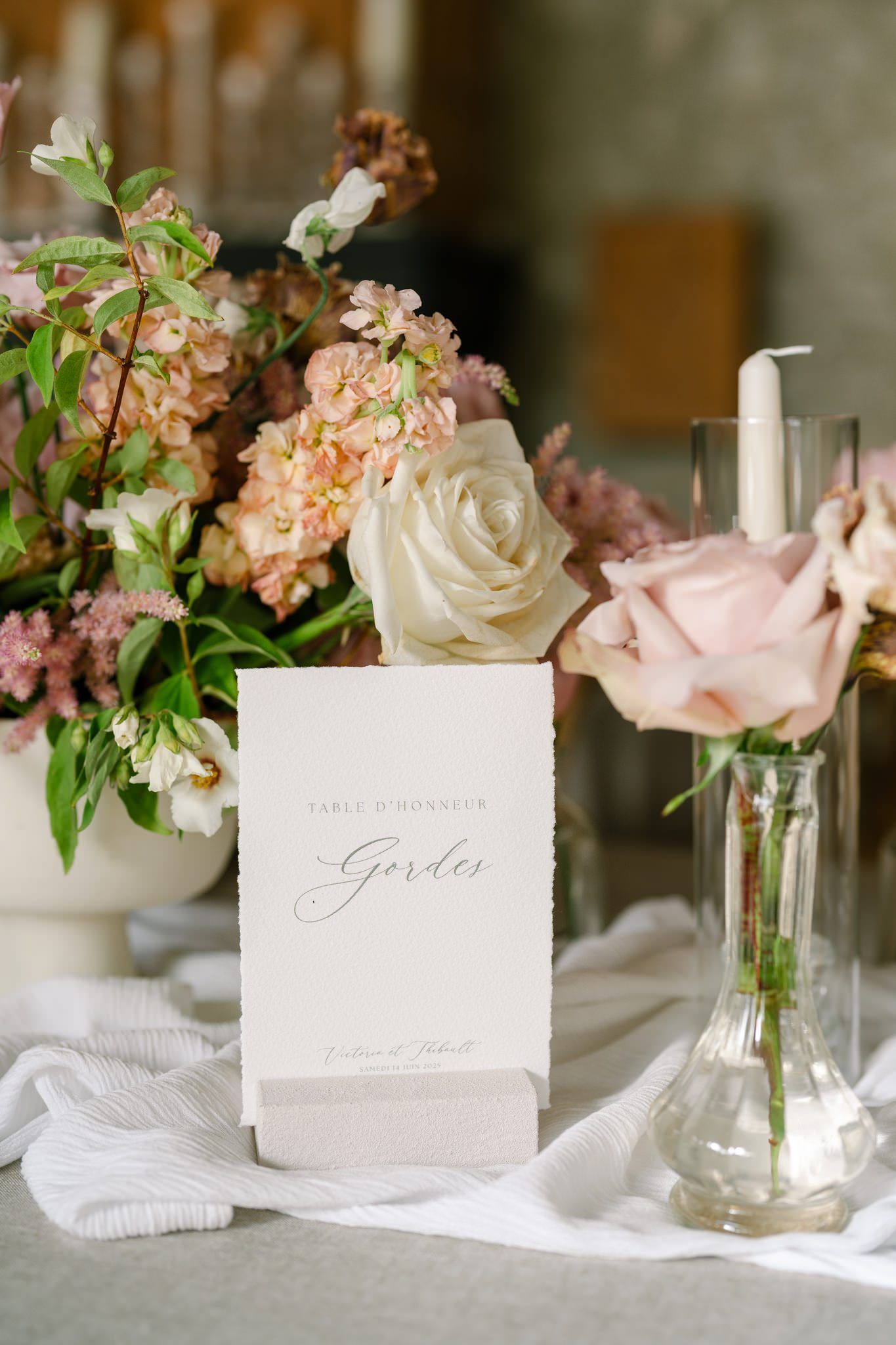 Elegant table settings with white place cards, small floral arrangements, and crystal vases.