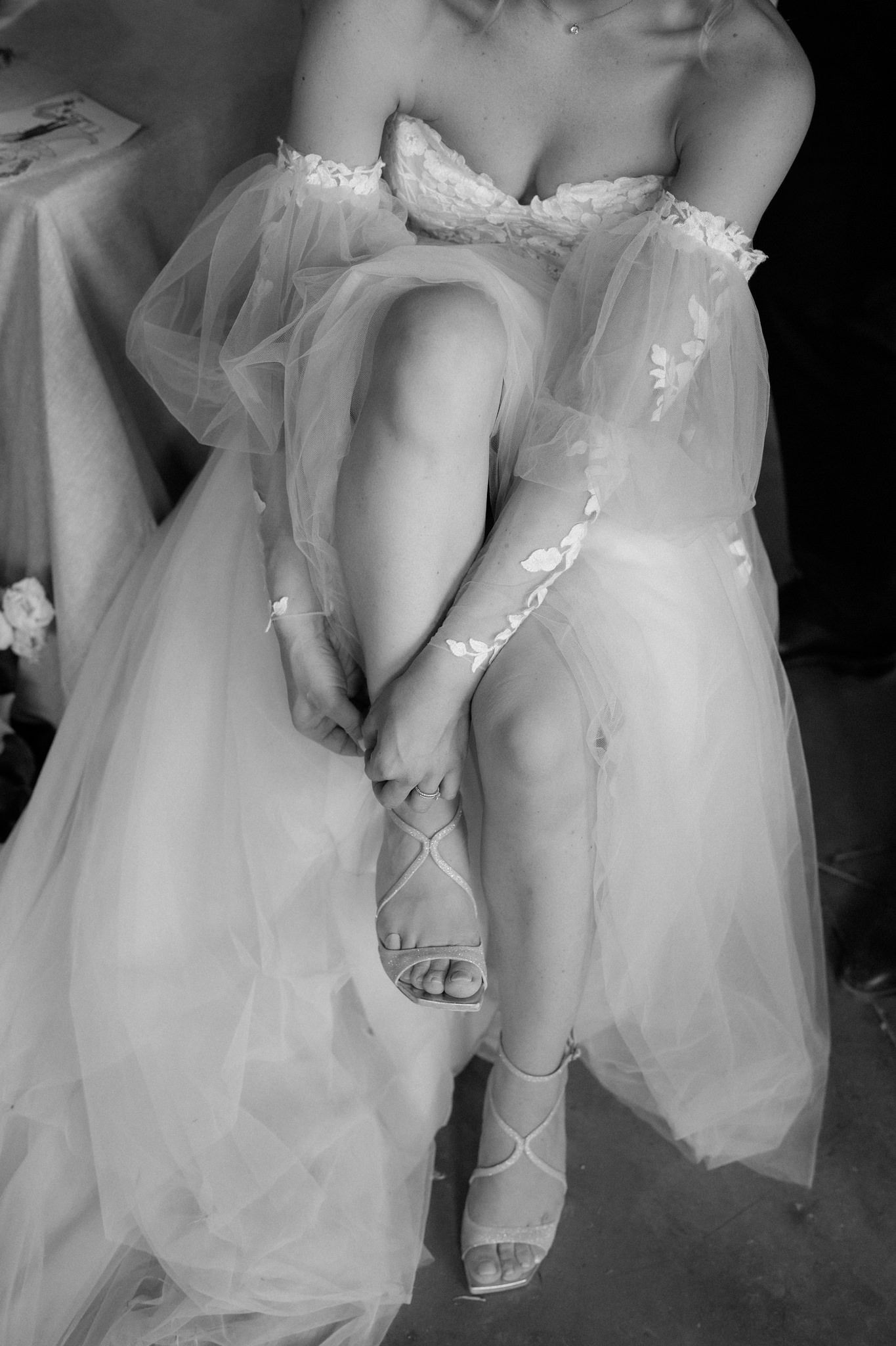 Close-up details of a white wedding dress and shoes.